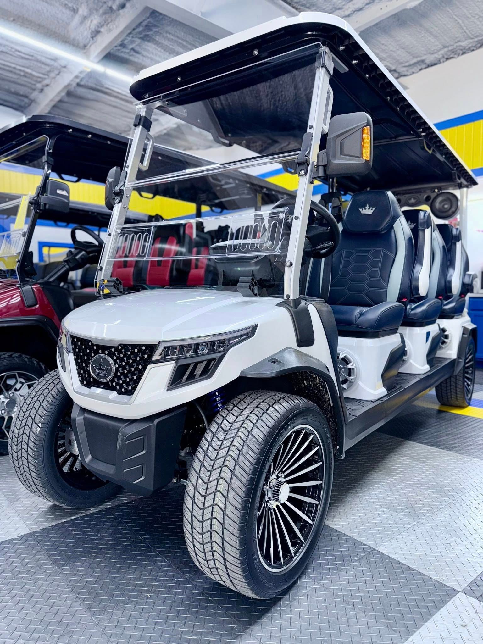 A white golf cart is parked in a garage.