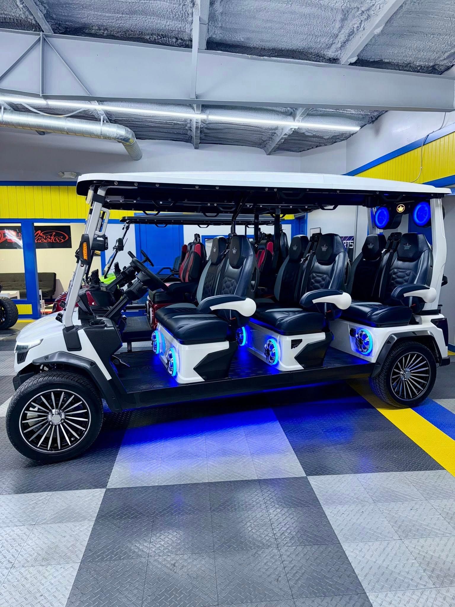 A golf cart with a lot of seats is parked in a garage.