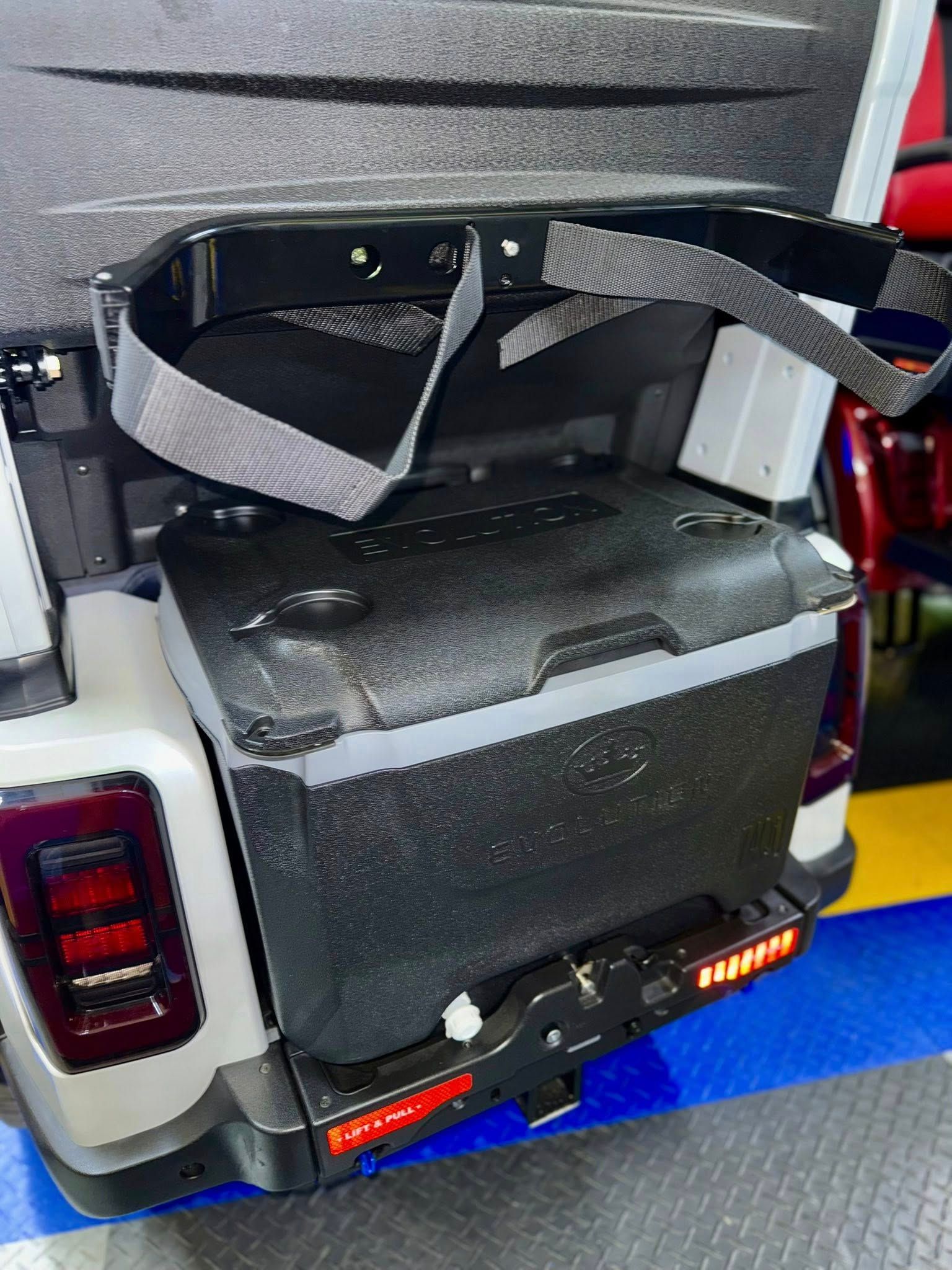A jeep with a cooler attached to the back of it.