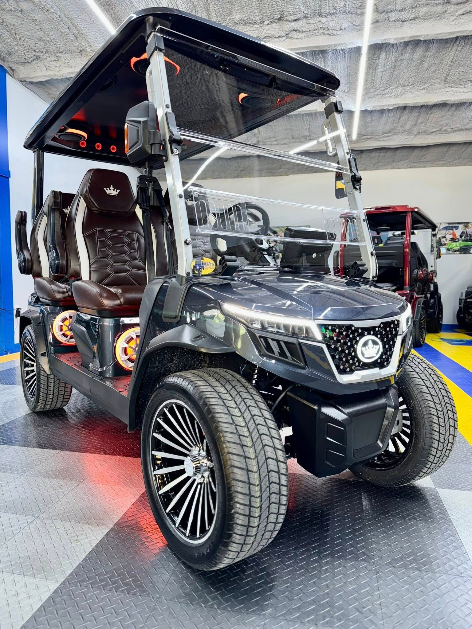 A black golf cart is parked in a garage.