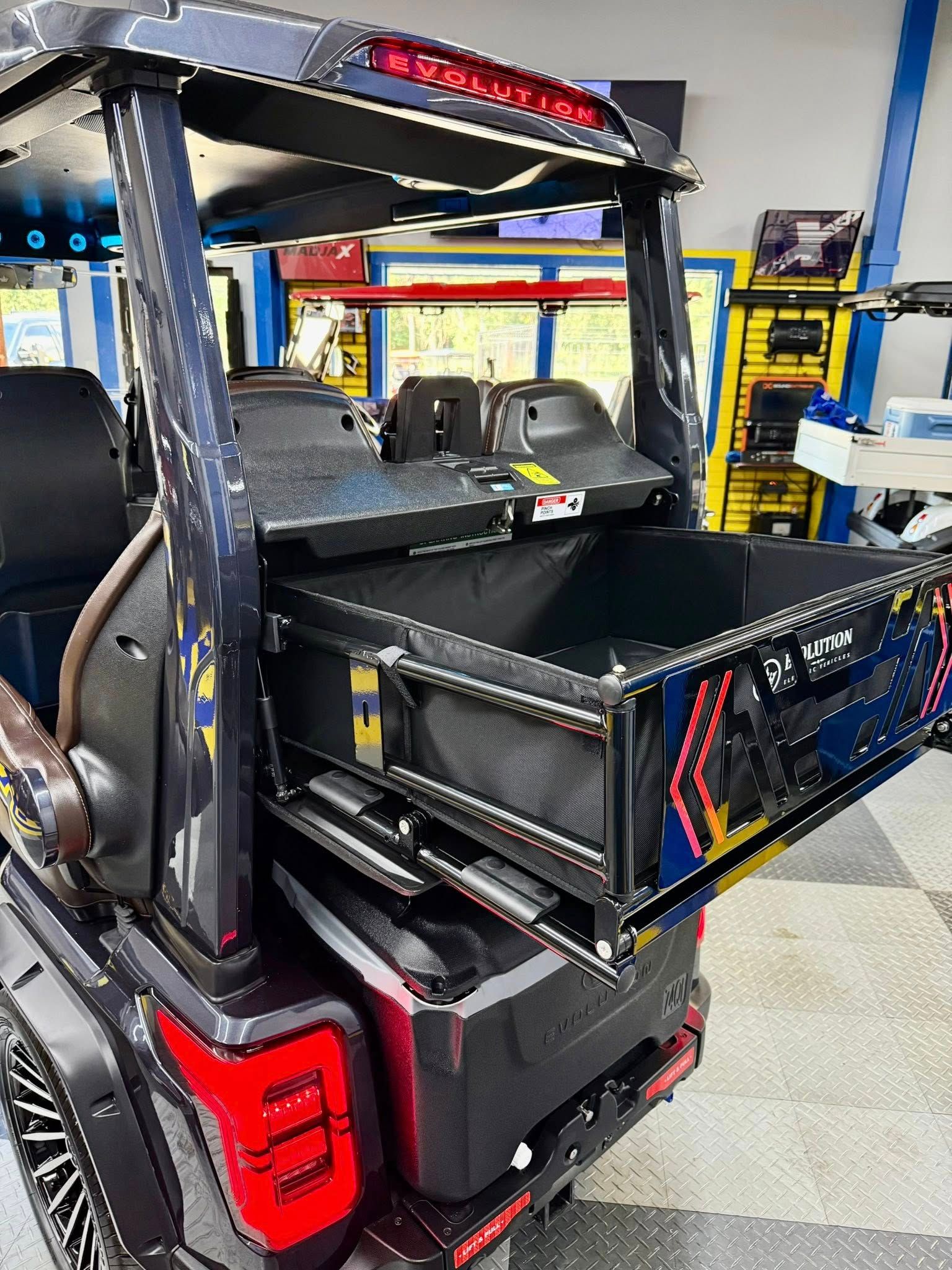 A black jeep with a drawer in the back is parked in a garage.