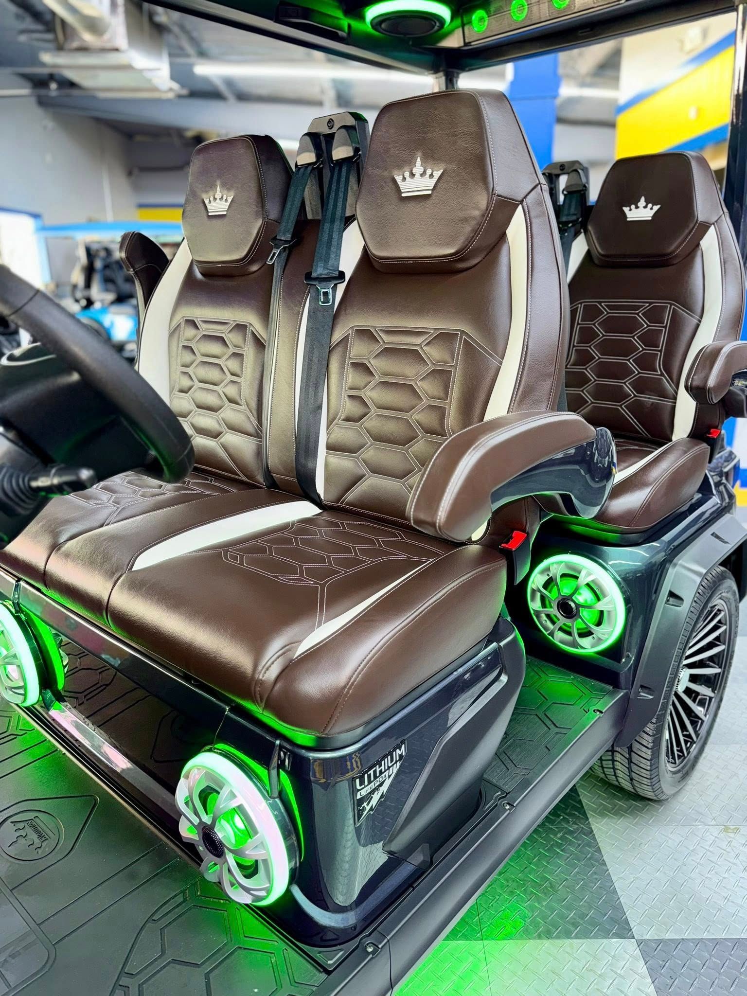 A golf cart with a crown on the seats is sitting in a garage.