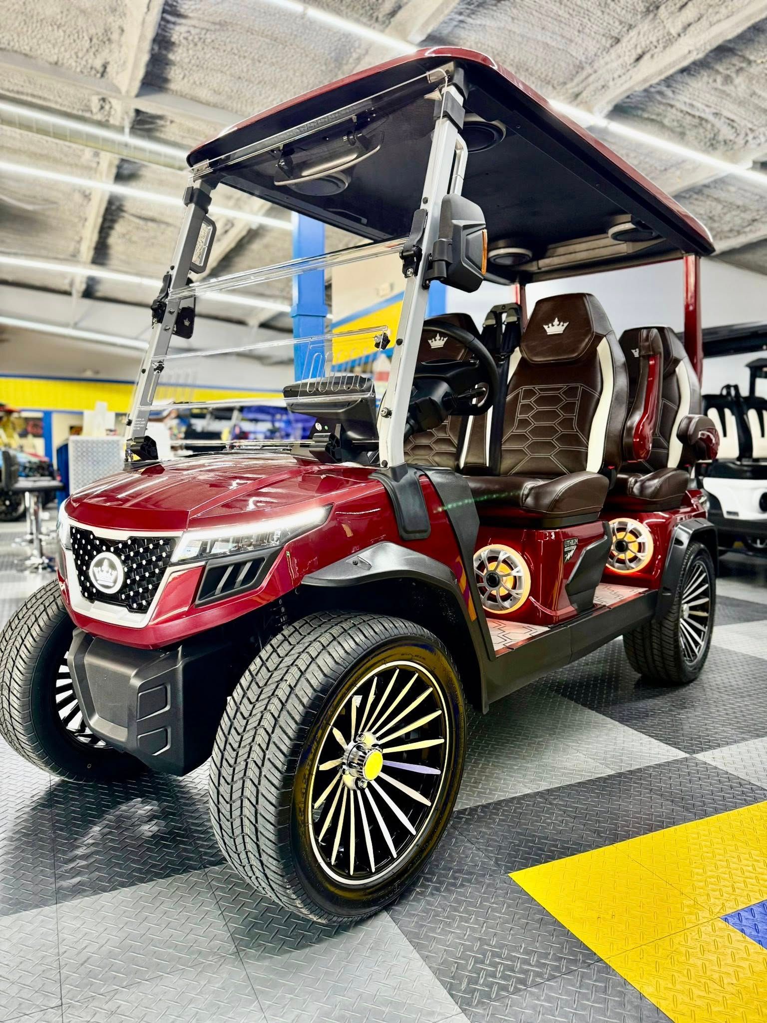 A red golf cart is parked in a showroom.