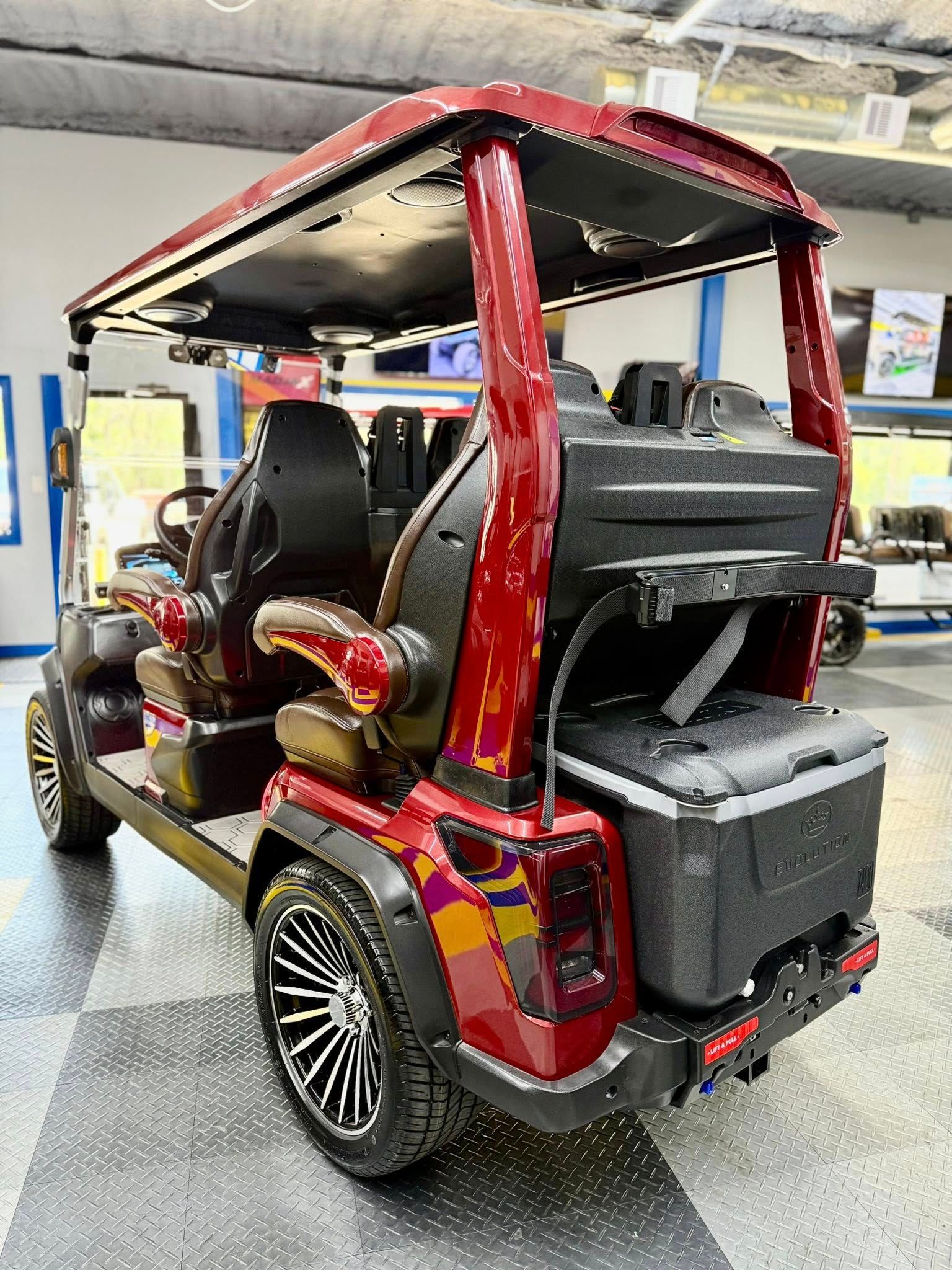 A red golf cart with a cooler in the back is parked in a garage.