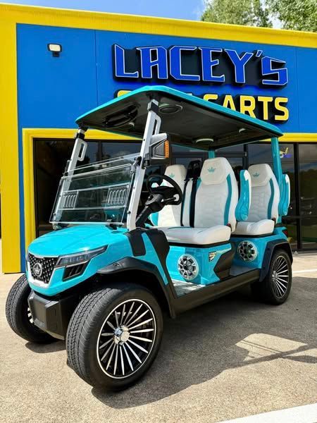 A blue and white golf cart is parked in front of a lacey 's carts store.