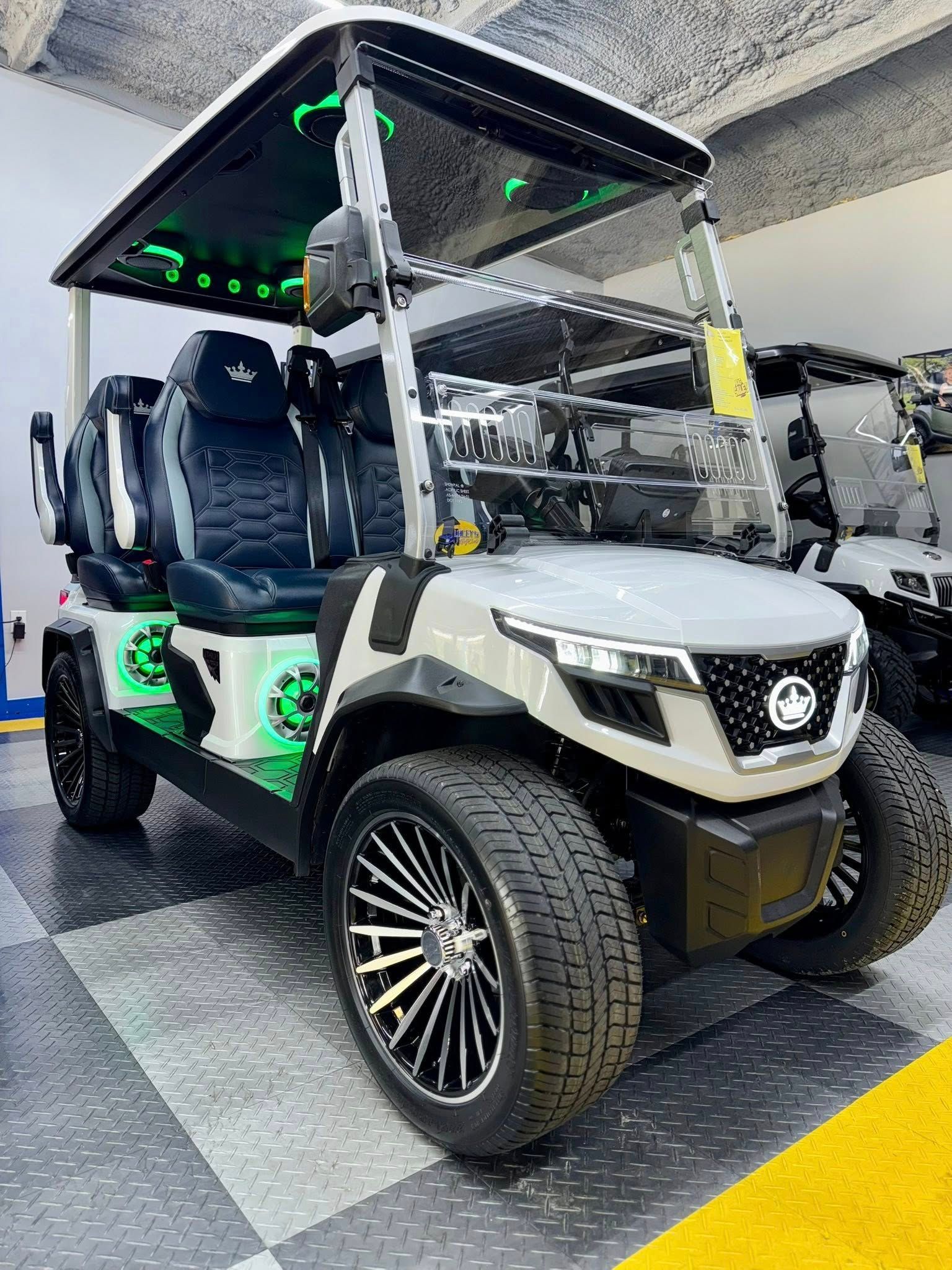 A white golf cart is parked in a garage.