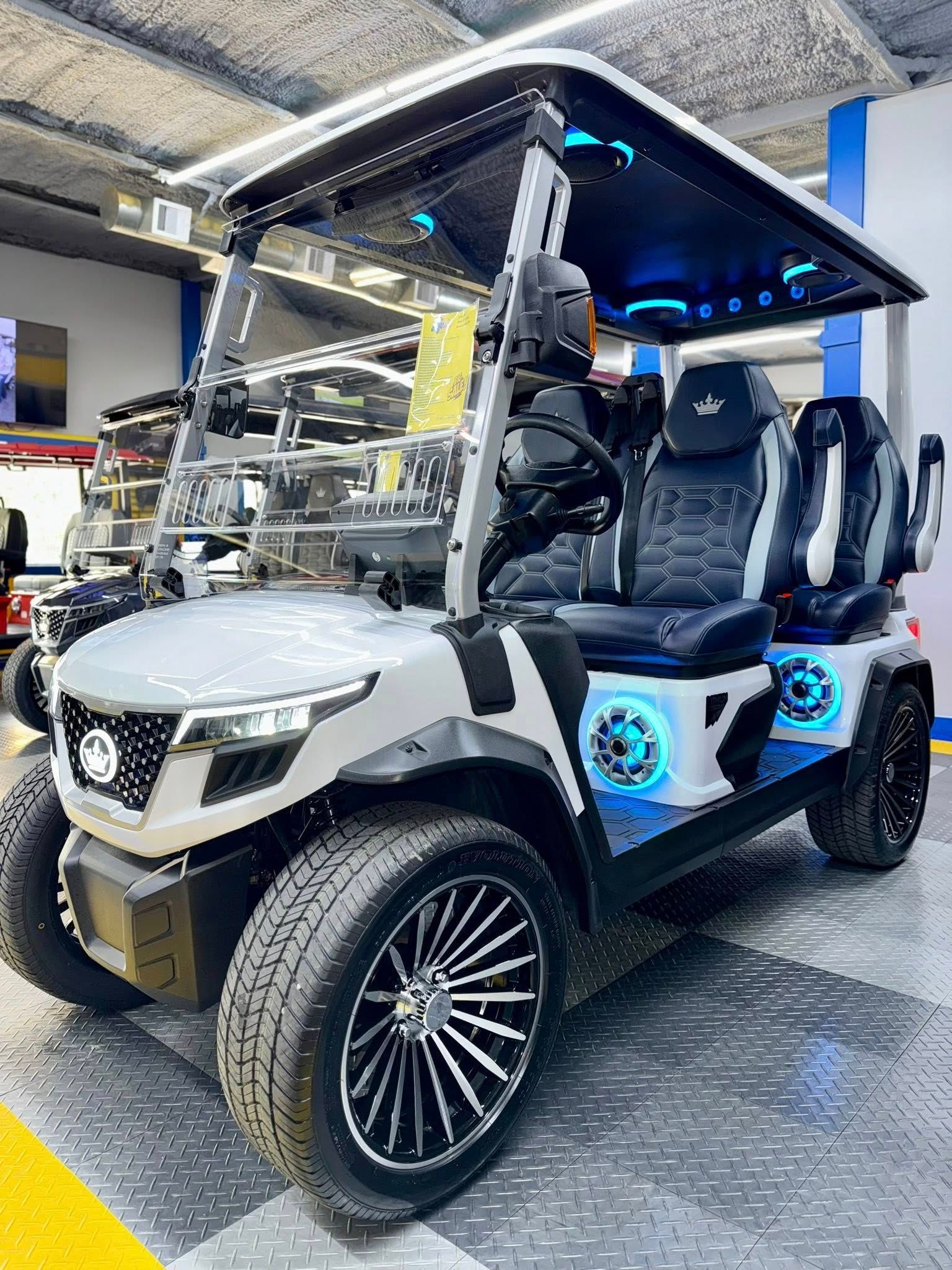 A white golf cart is parked in a garage.