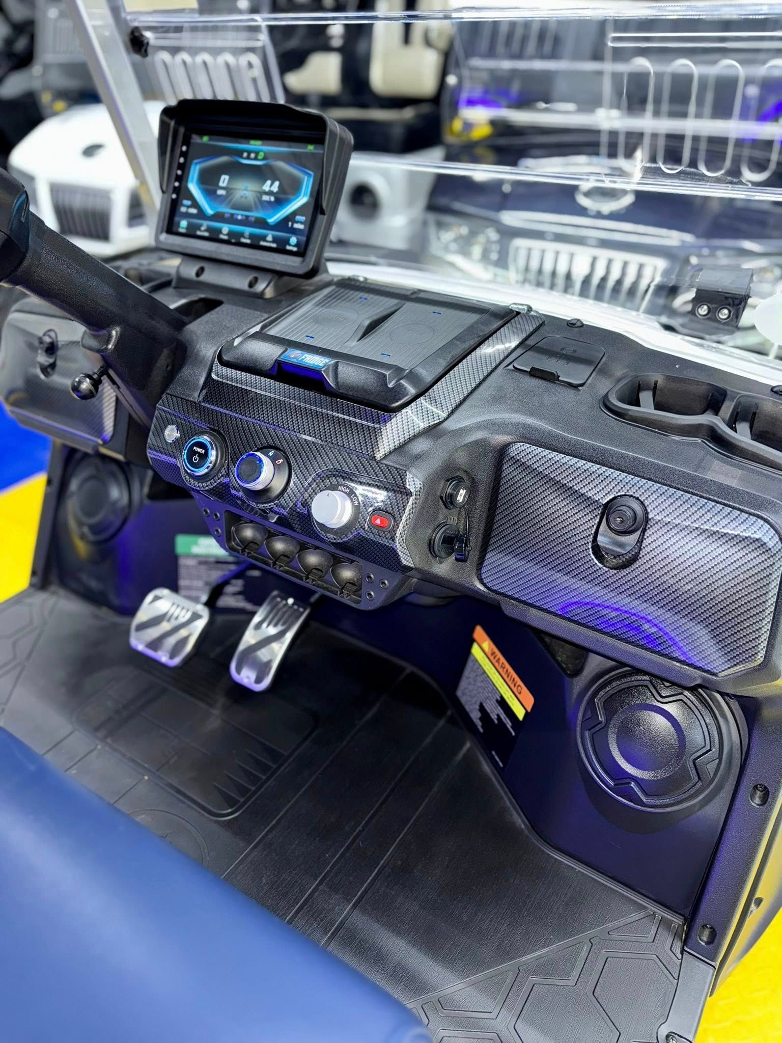 A close up of the dashboard of a boat with a monitor and speakers.