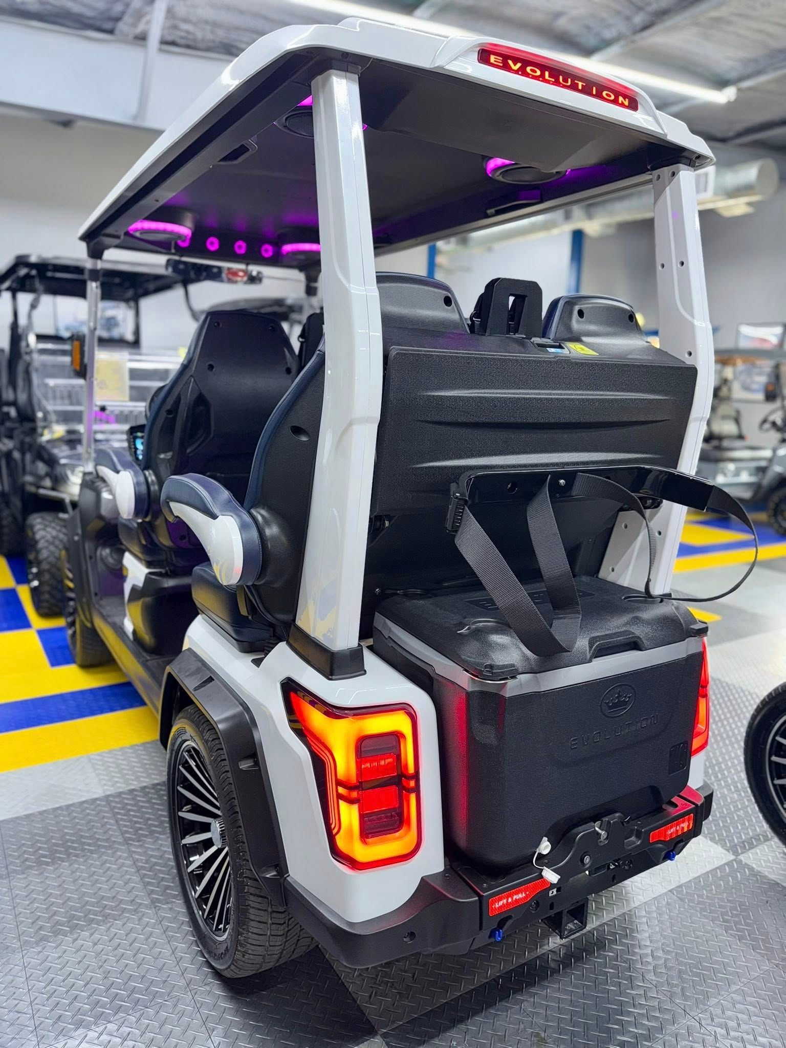 A white golf cart is parked in a garage.