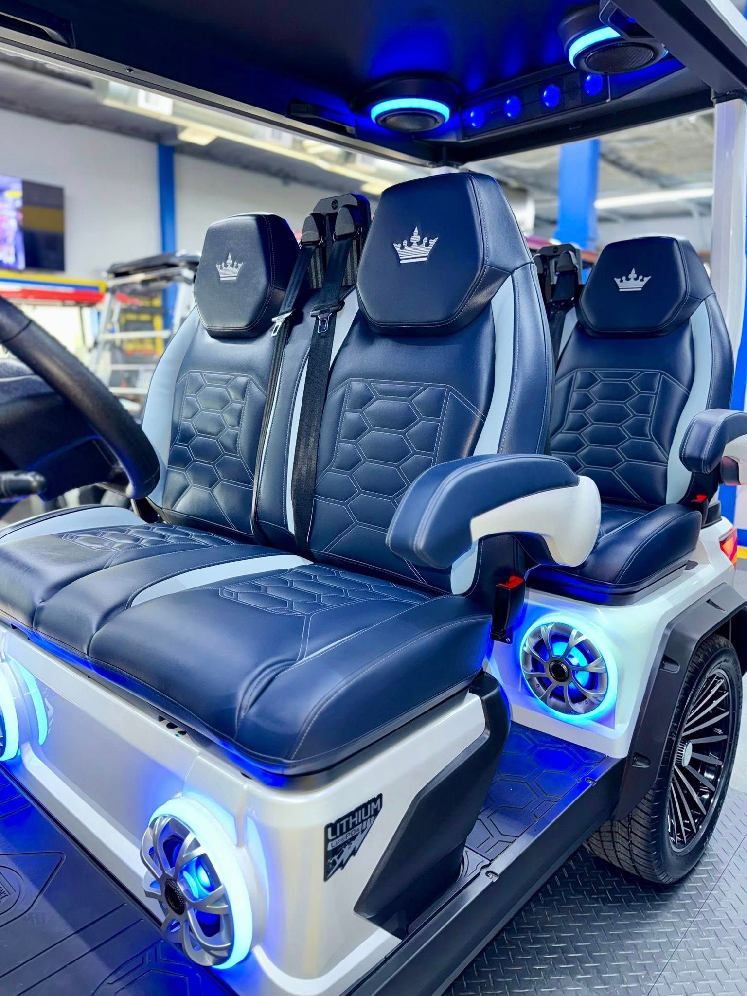 A golf cart with blue and white seats and speakers.