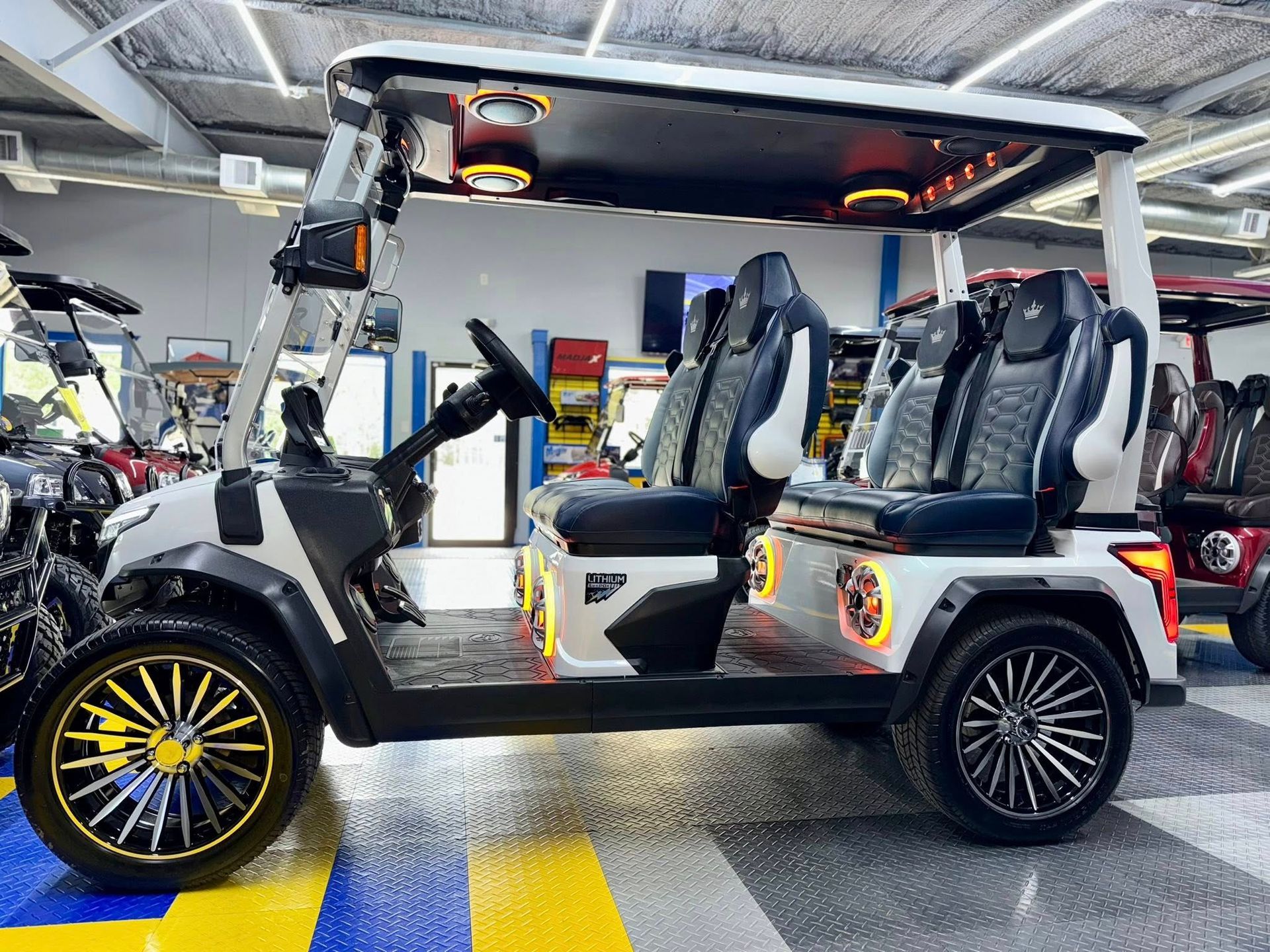 A golf cart is parked in a garage with other golf carts.