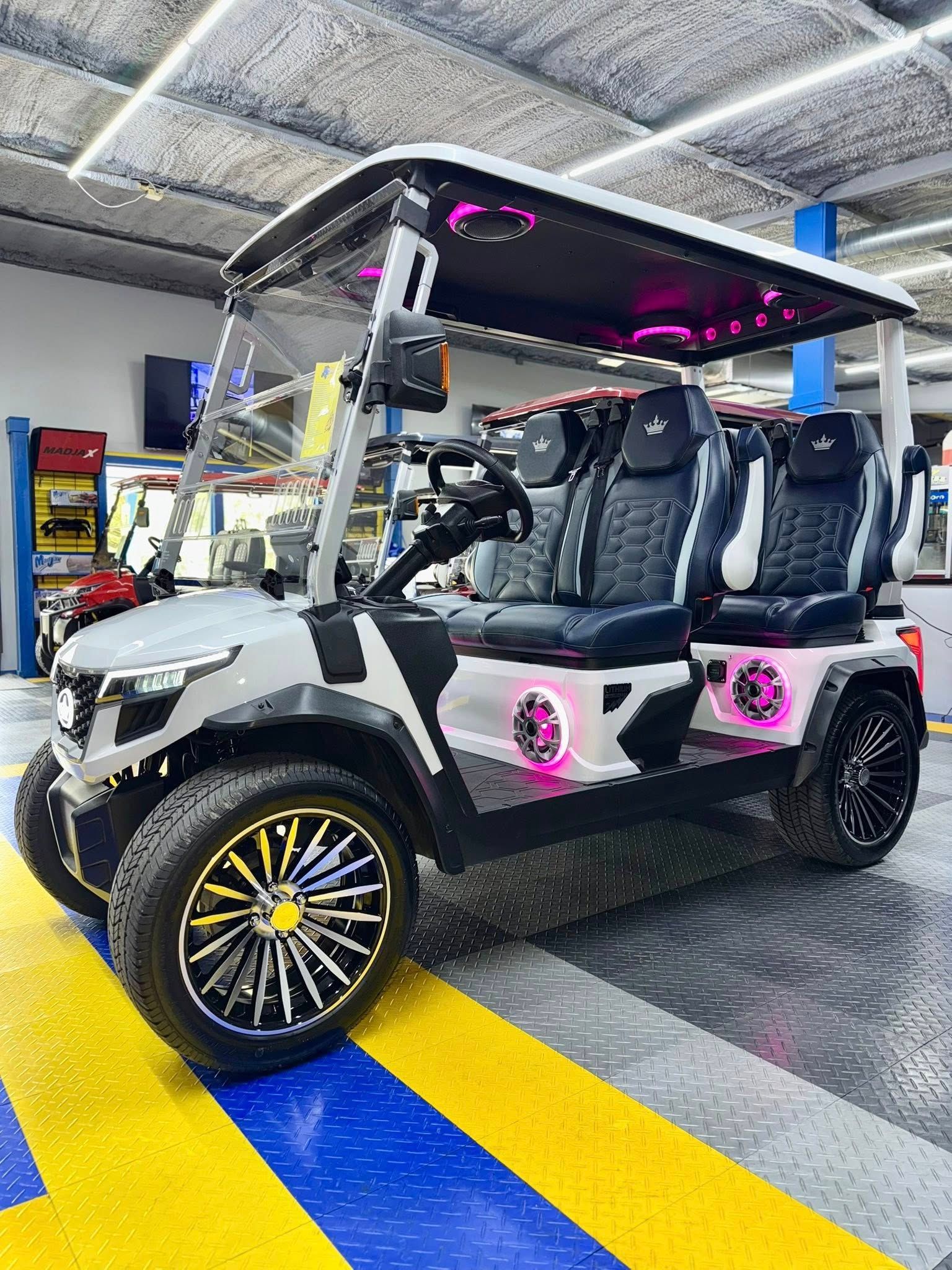 A golf cart is parked in a garage with a yellow and blue striped floor.
