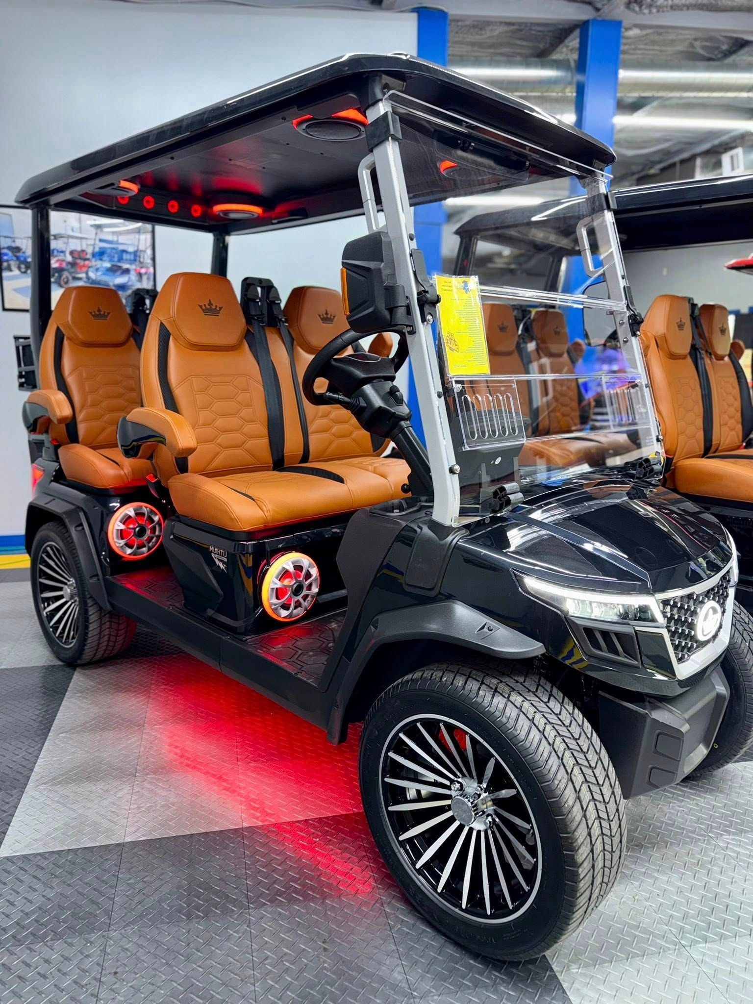 Black golf cart with brown leather seats, underglow, and custom wheels.