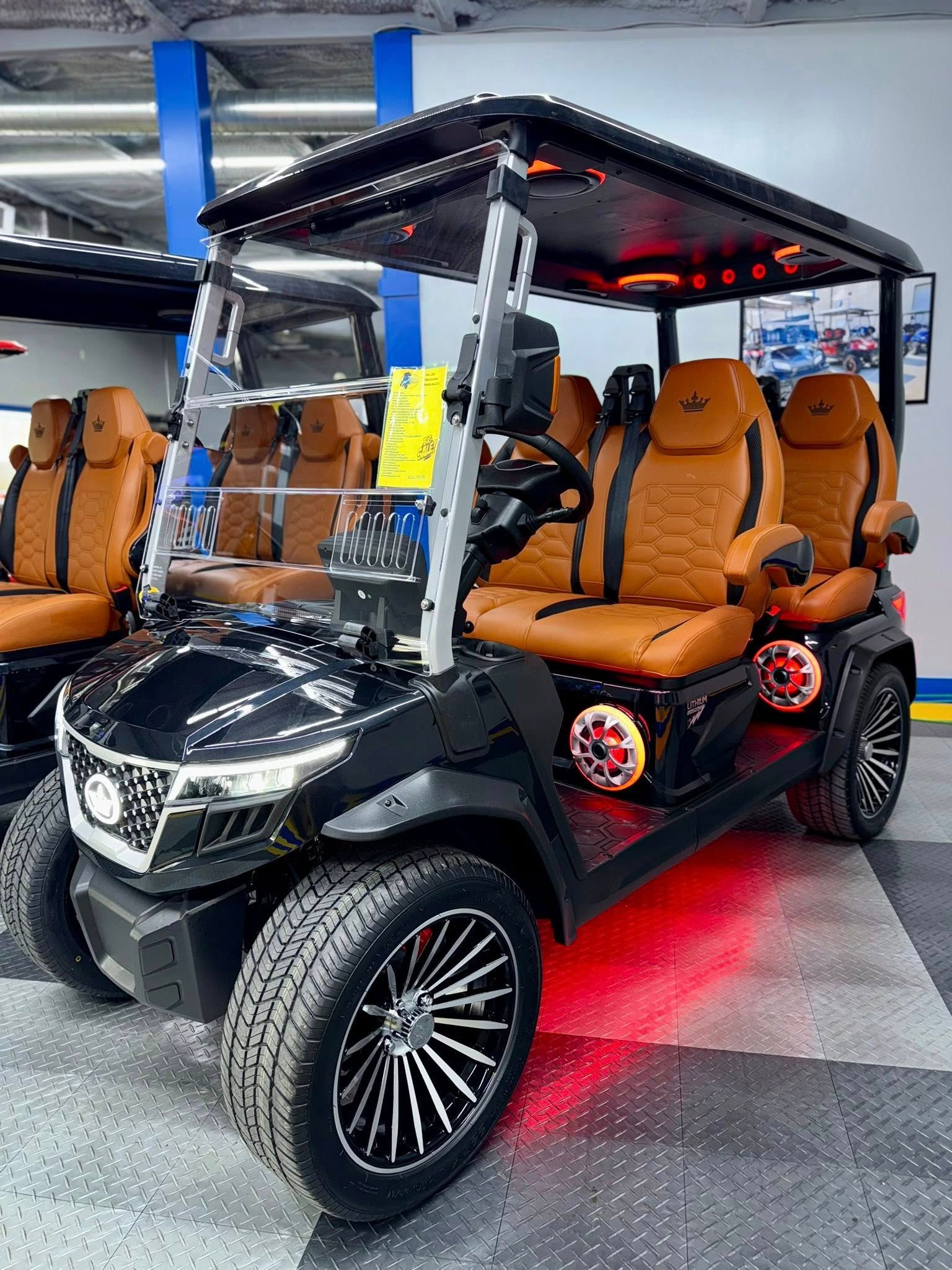 Black golf cart with tan and black seats, LED lights, and custom wheels.