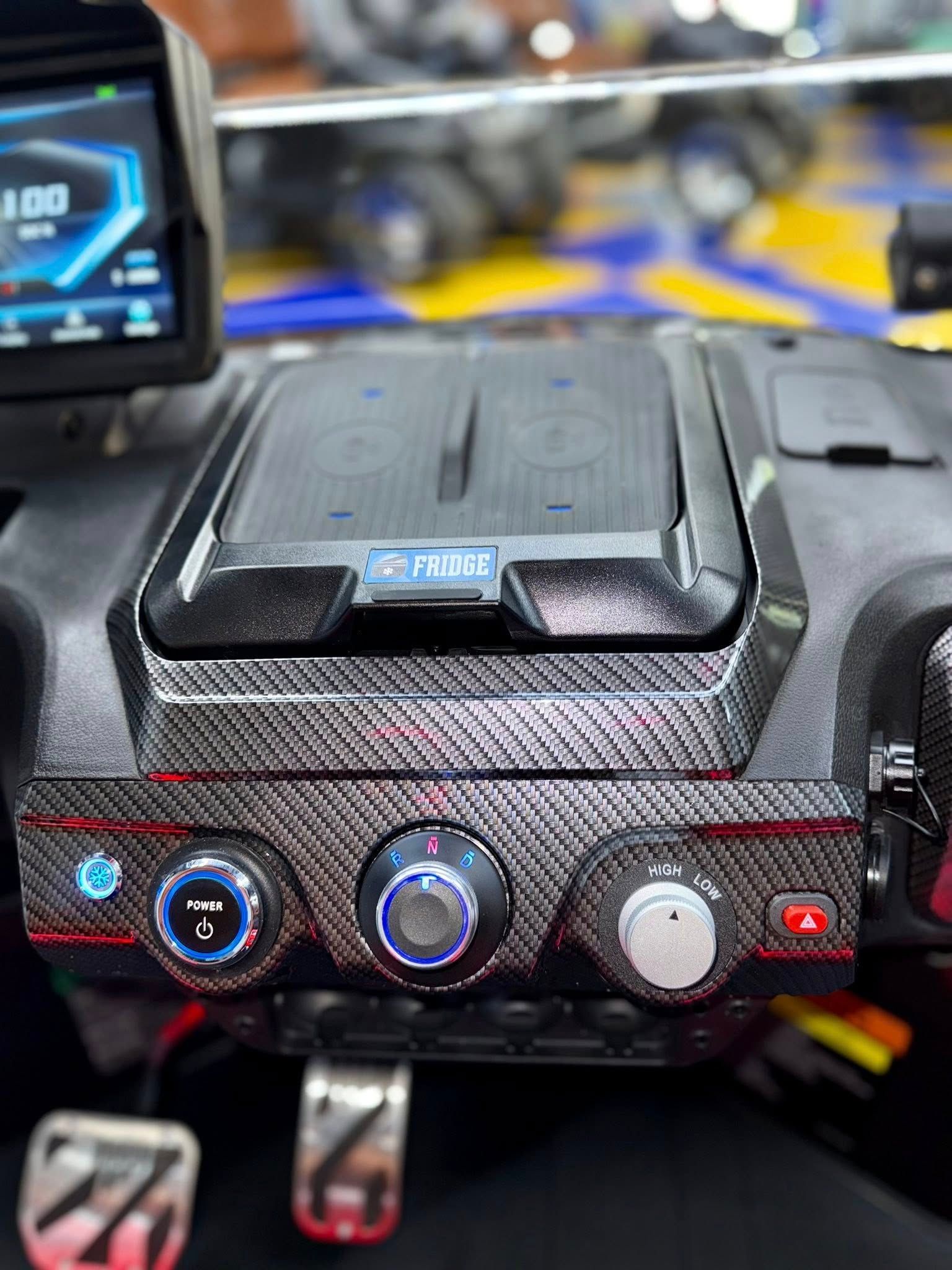 Dashboard with carbon fiber pattern, including climate controls, wireless charging, and a digital display showing speed.