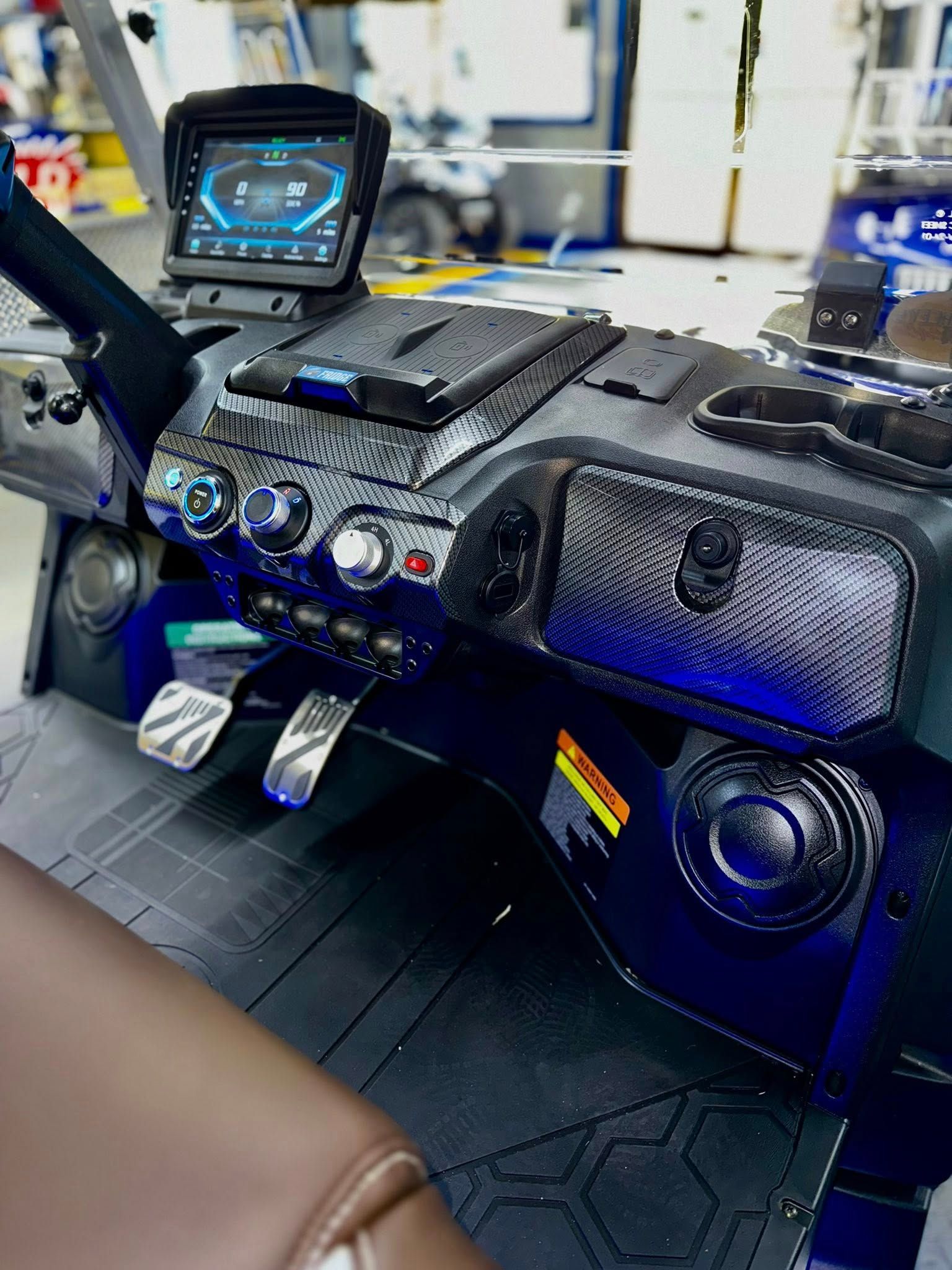 Golf cart dashboard with digital display, controls, cupholders, and speakers.
