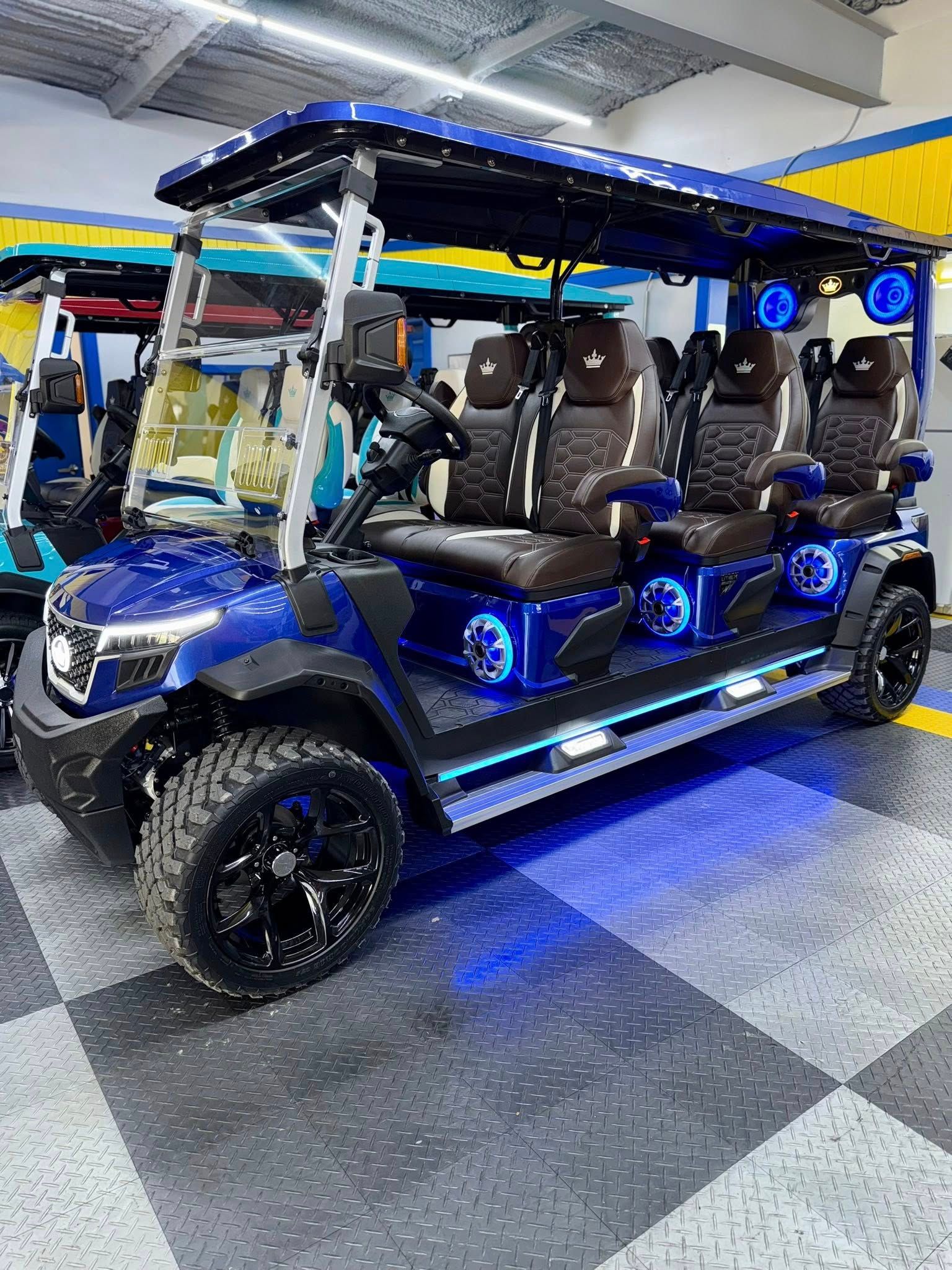 Blue custom golf cart with black rims, LED lights, and brown and black seats.