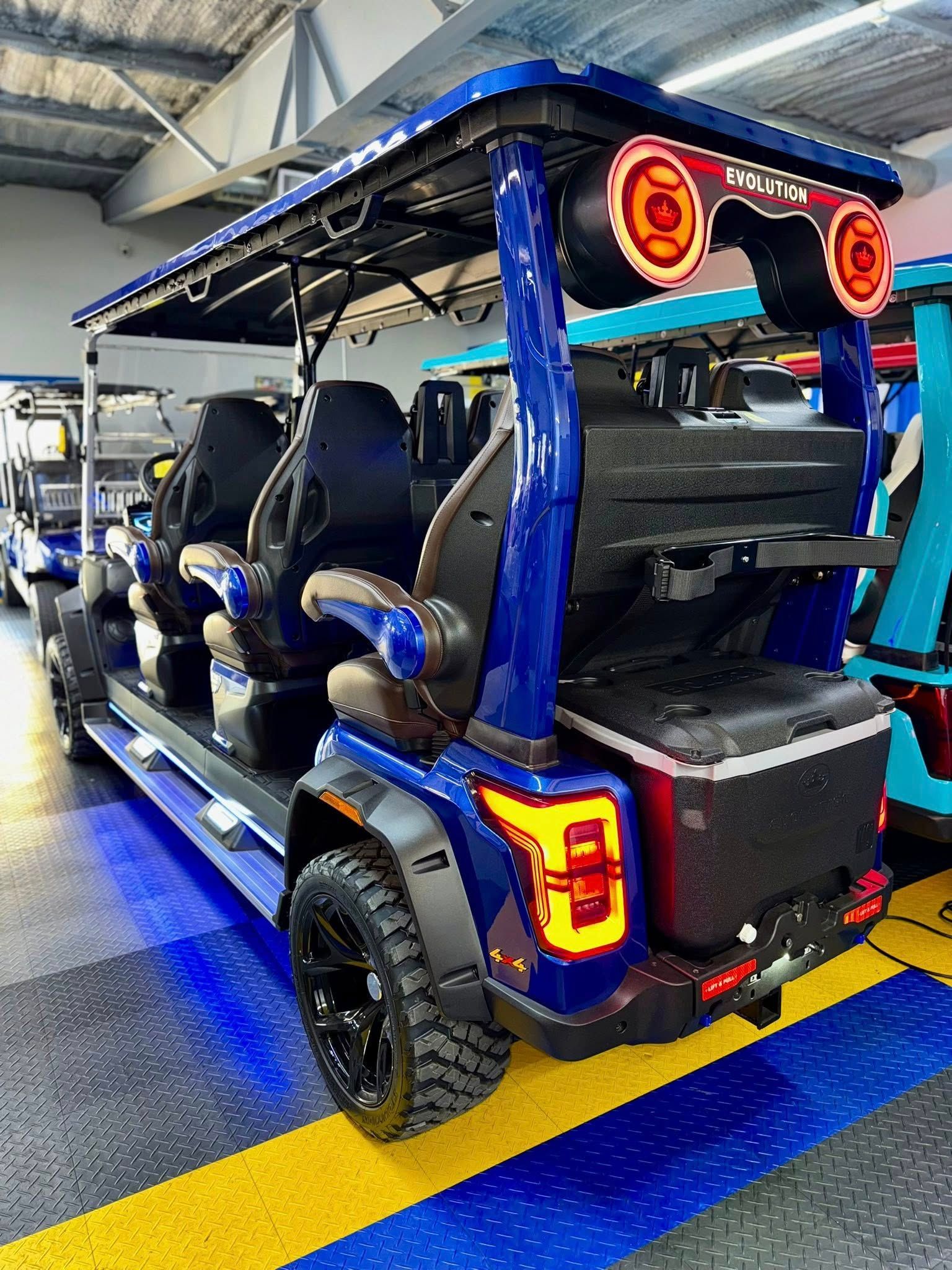 Blue golf cart with six seats, black wheels, and orange taillights.