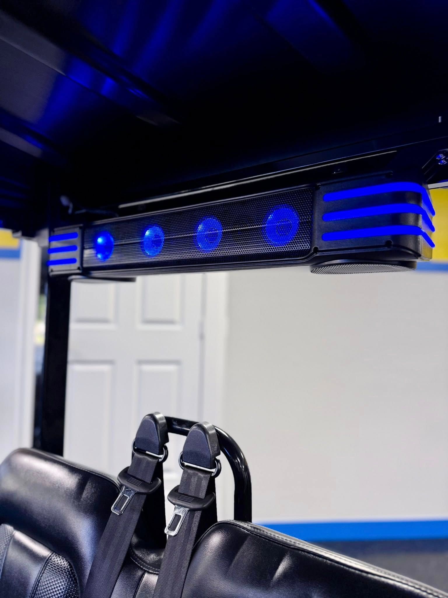 Black golf cart with blue LED lights on roof, interior view.