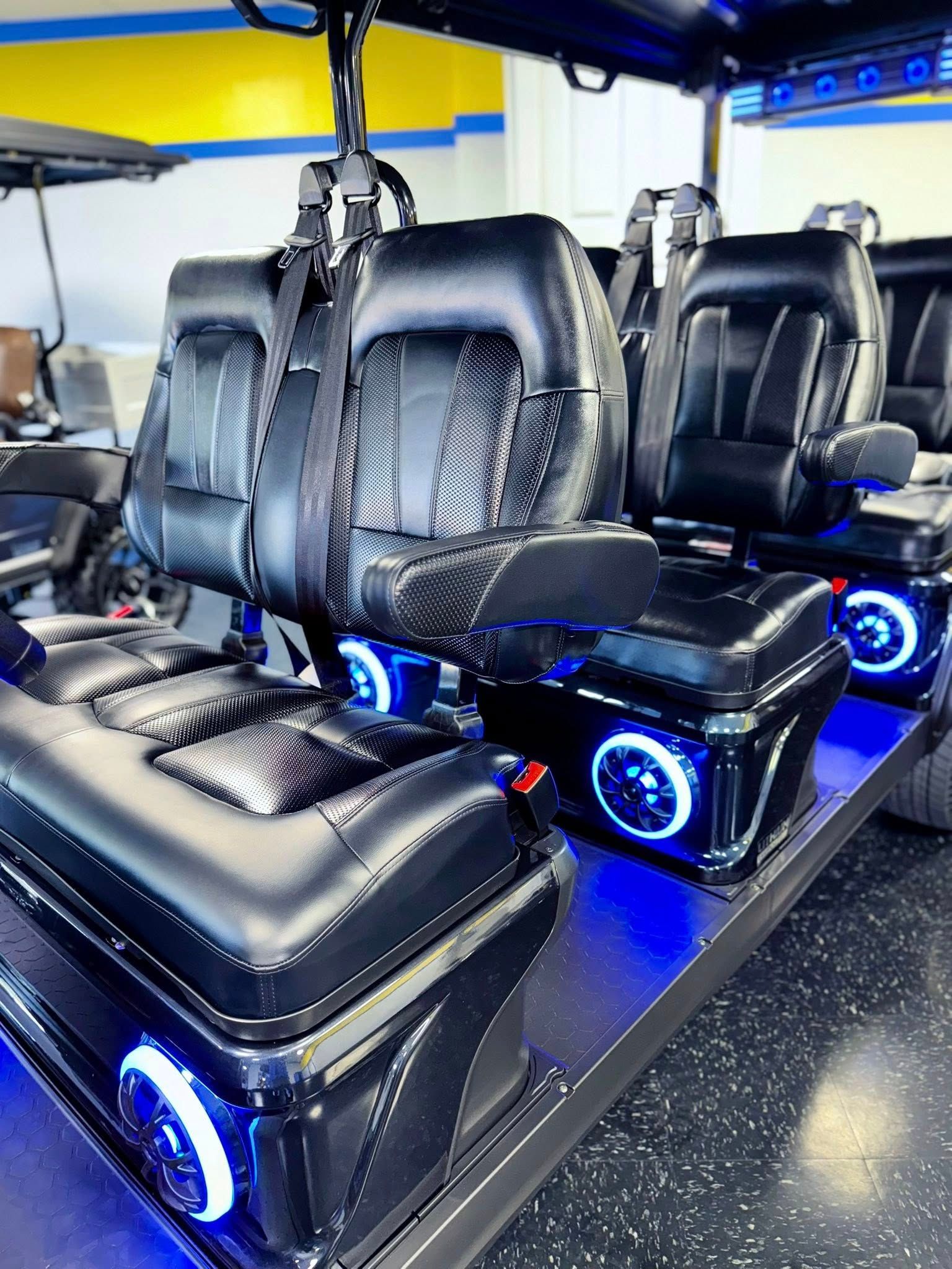 Custom golf cart interior with black leather seats and blue accent lights.