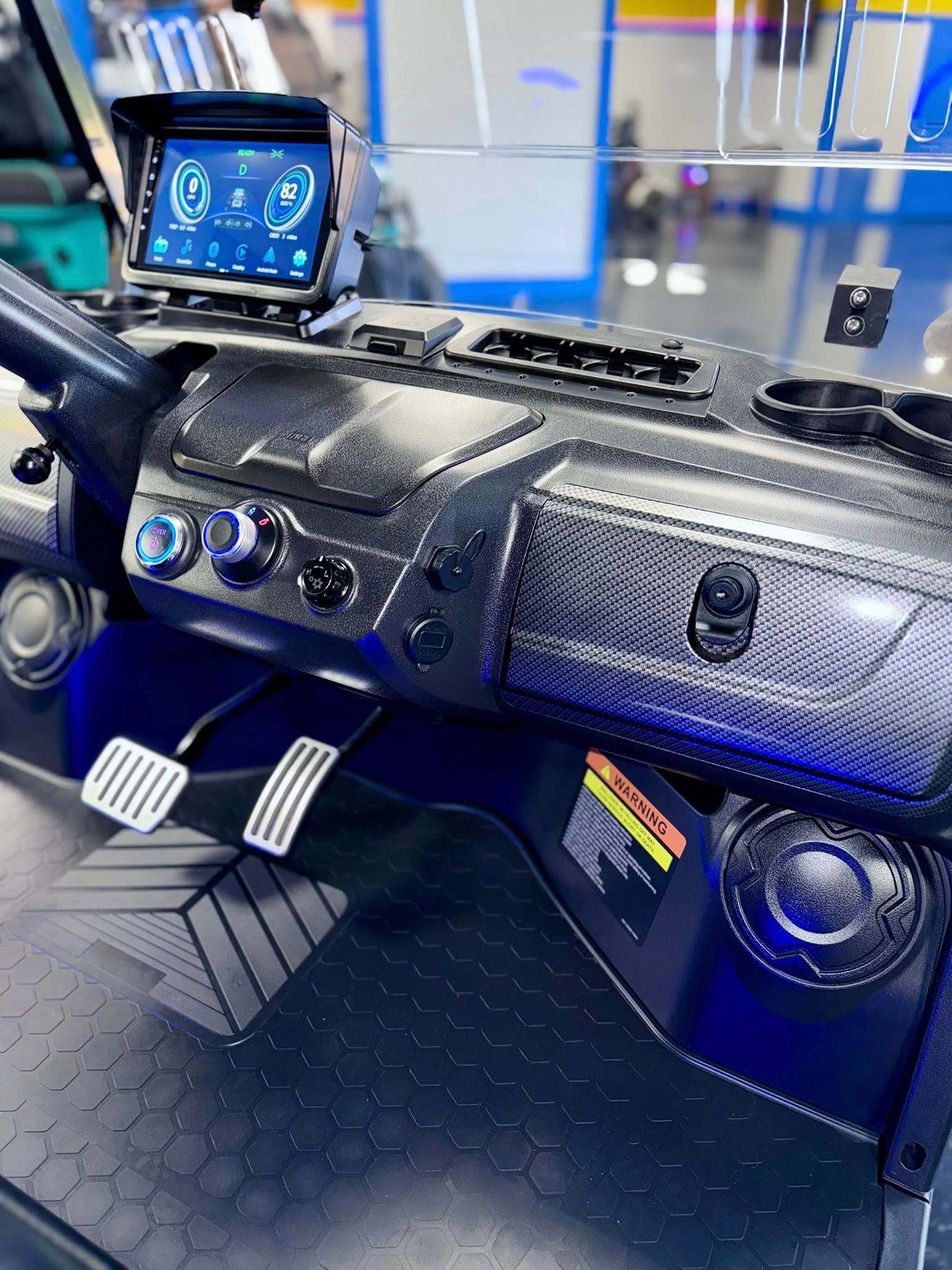 Dashboard of a golf cart featuring digital display, dark interior, and metallic accents.