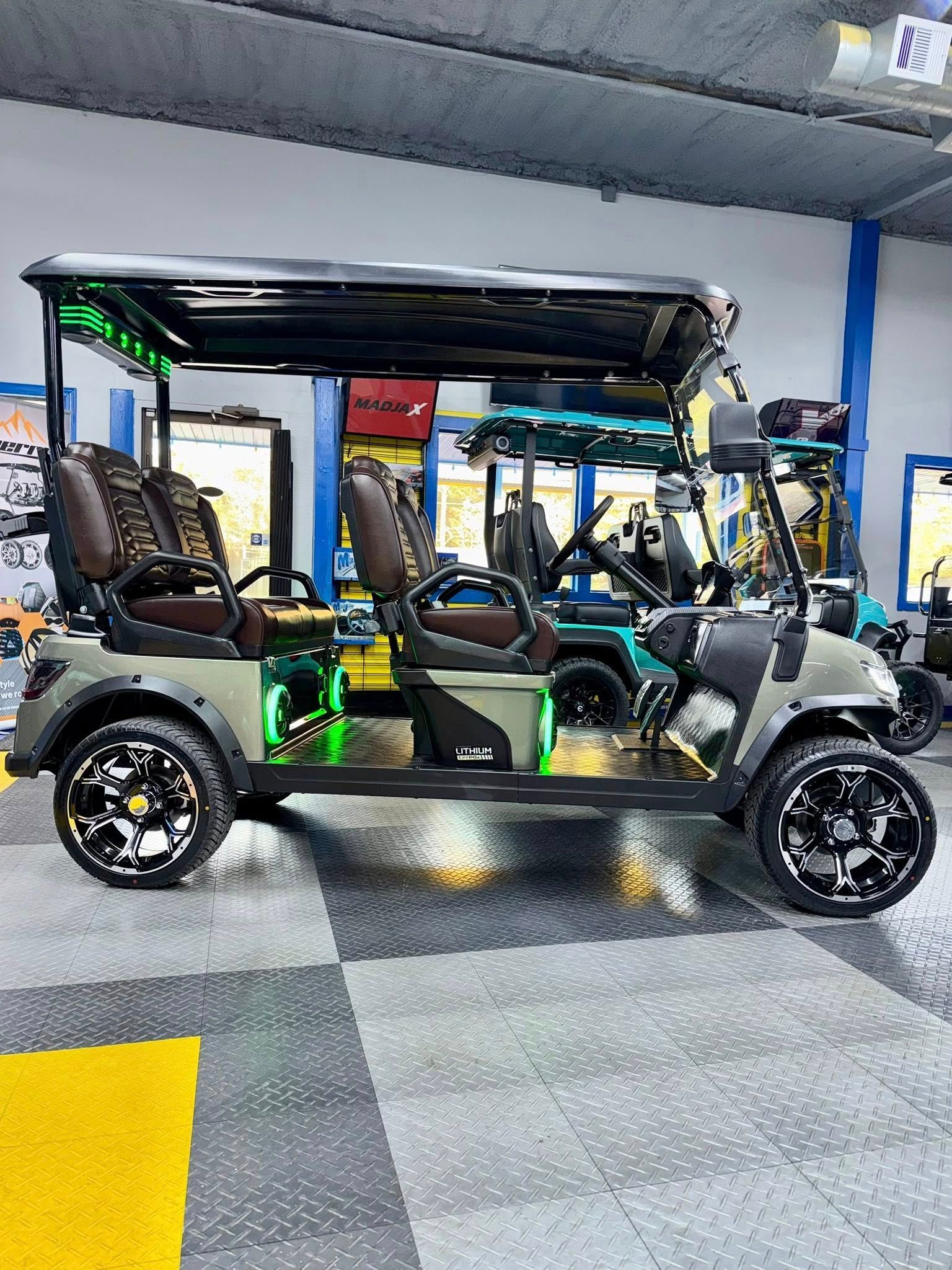 Custom olive green golf cart with black accents, LED lights, and black wheels.