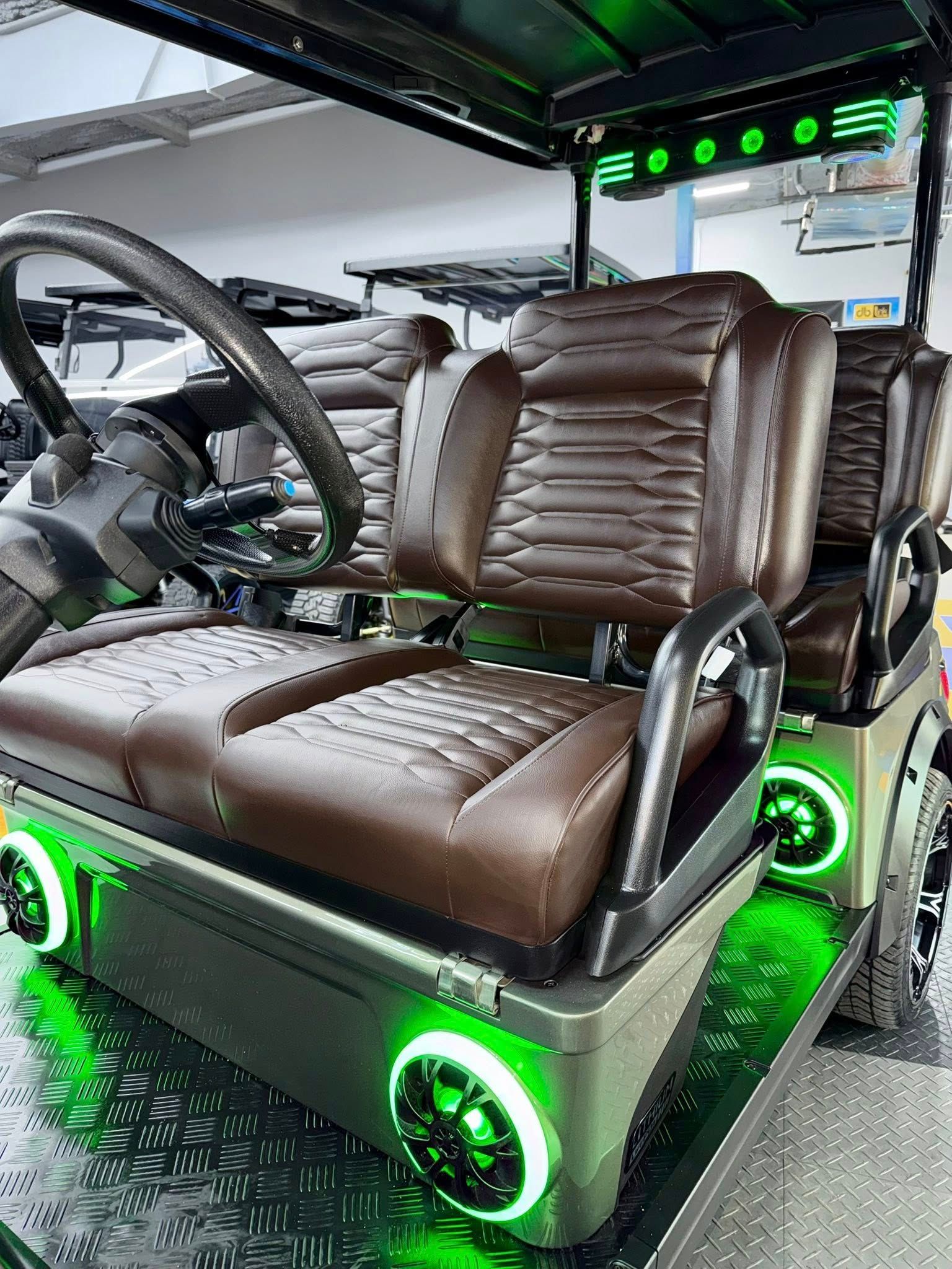Custom golf cart with brown seats and green underglow lights.