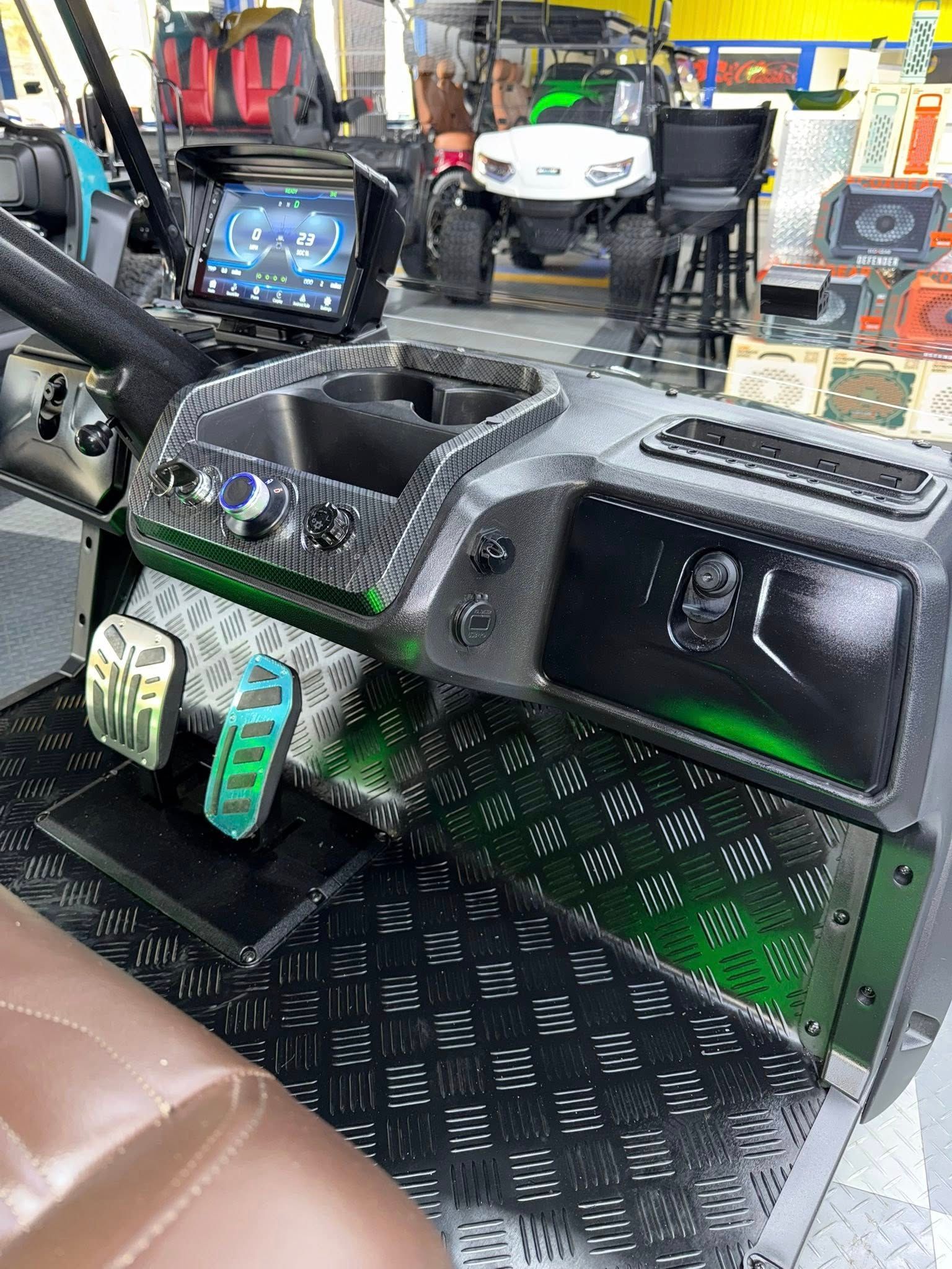 Interior of a custom vehicle with a black and green dashboard and metal flooring.
