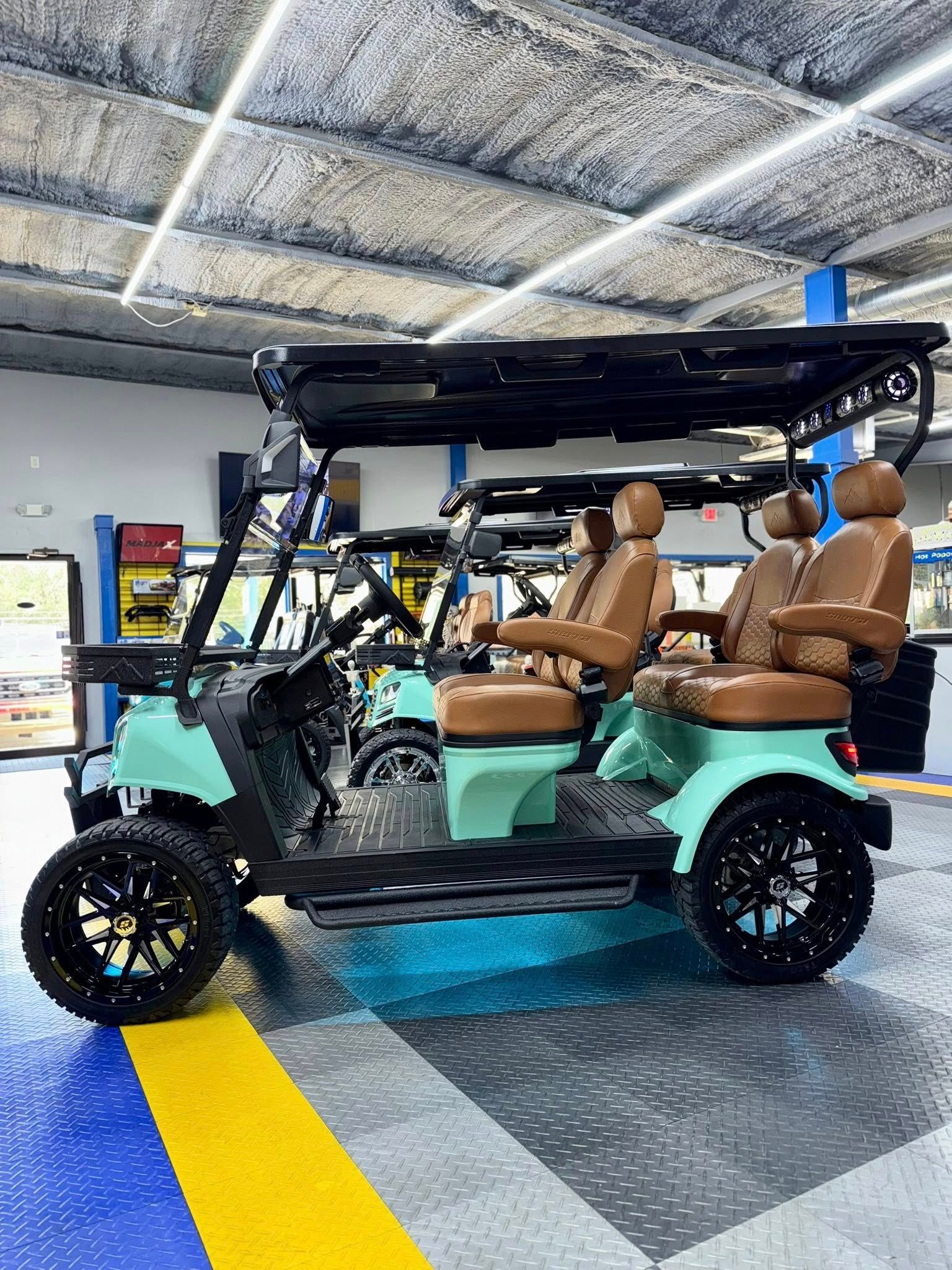 Mint green golf cart with brown seats, black wheels, inside a garage.
