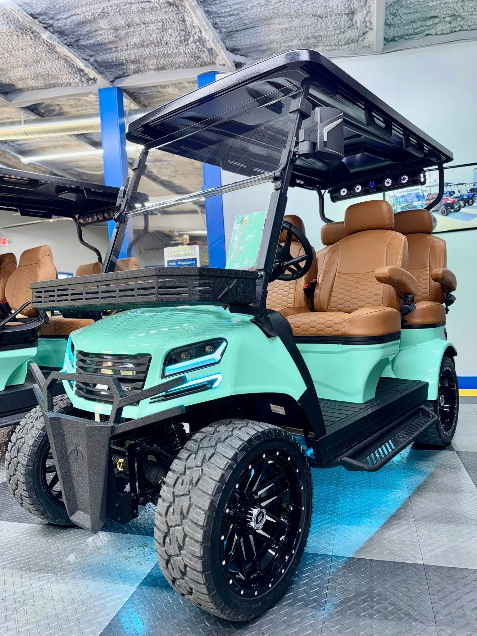 Mint green golf cart with black accents, brown seats, and large off-road tires.