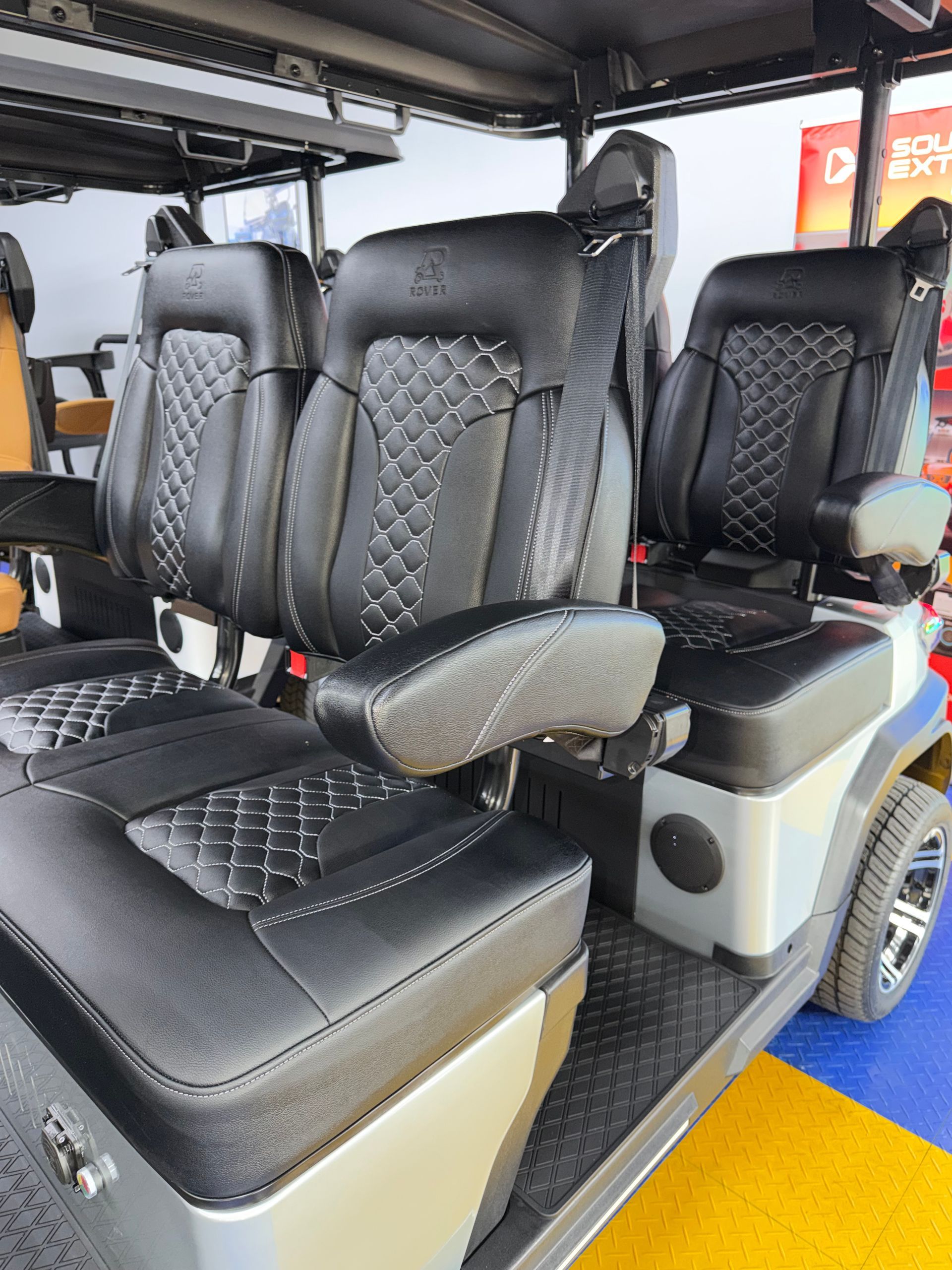 Three black leather seats with armrests in a vehicle interior, viewed from the side.