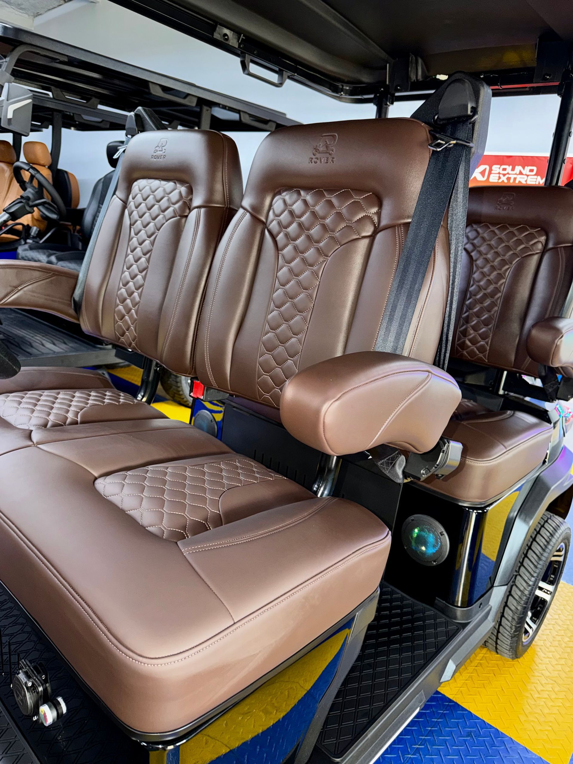 Brown quilted bus seats with armrests inside a vehicle interior