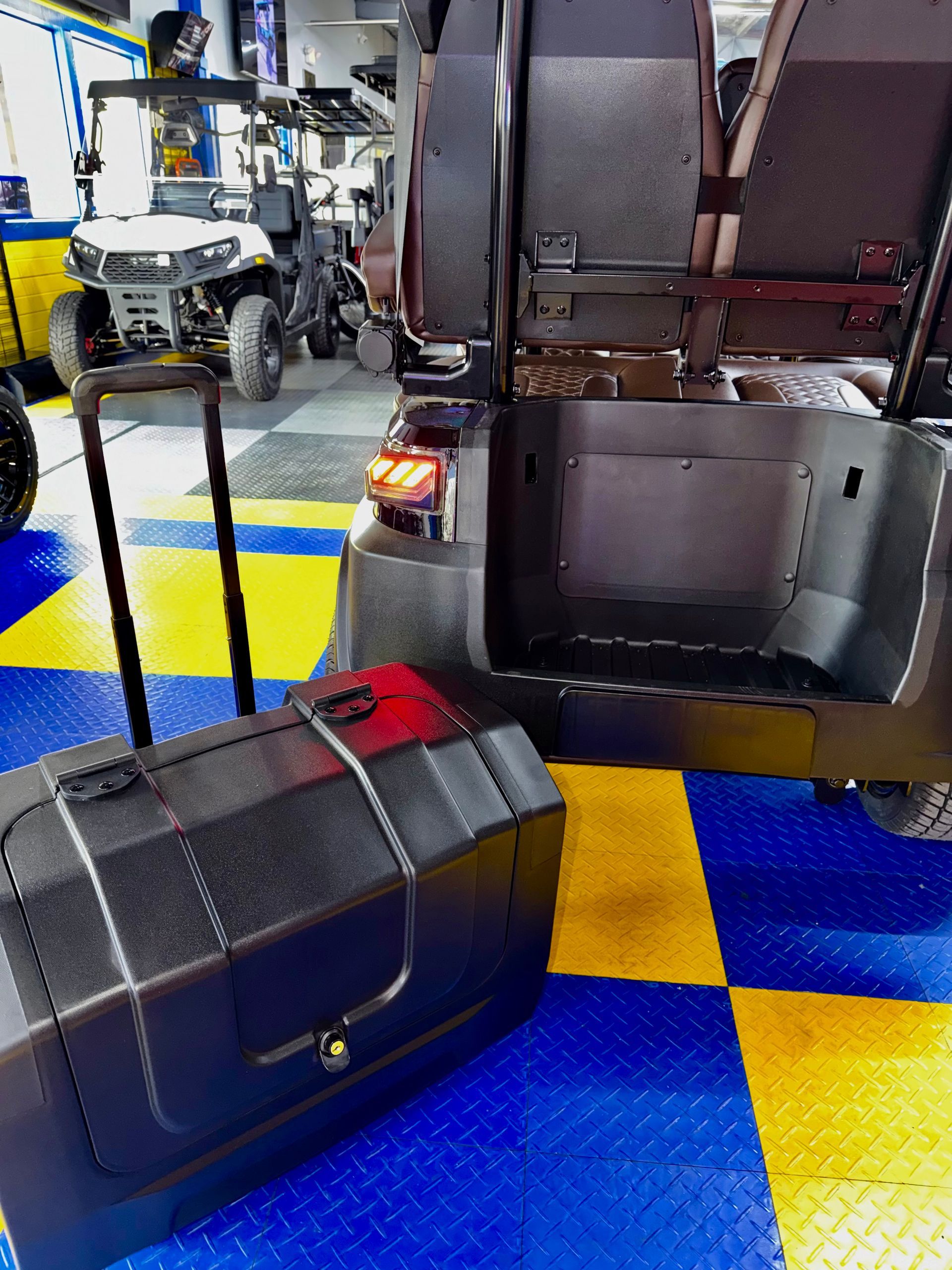 Suitcase and tote bag in a car trunk on a blue-and-yellow checkered garage floor