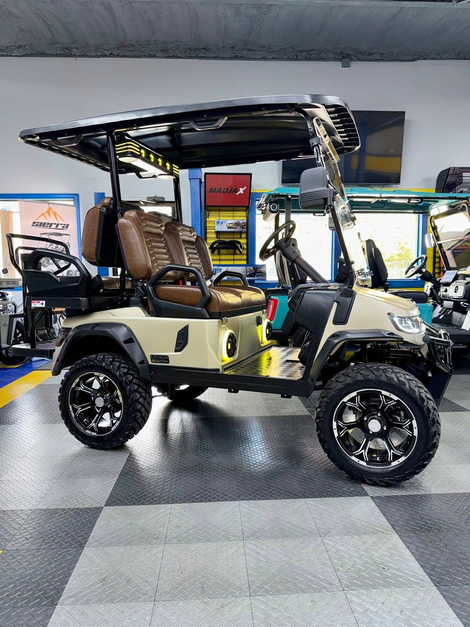 Tan golf cart with black roof and wheels, inside a showroom.