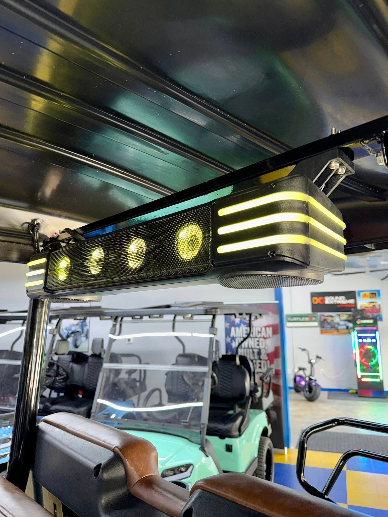 Overhead lighting fixture on a golf cart; yellow and black design. Golf cart in showroom.