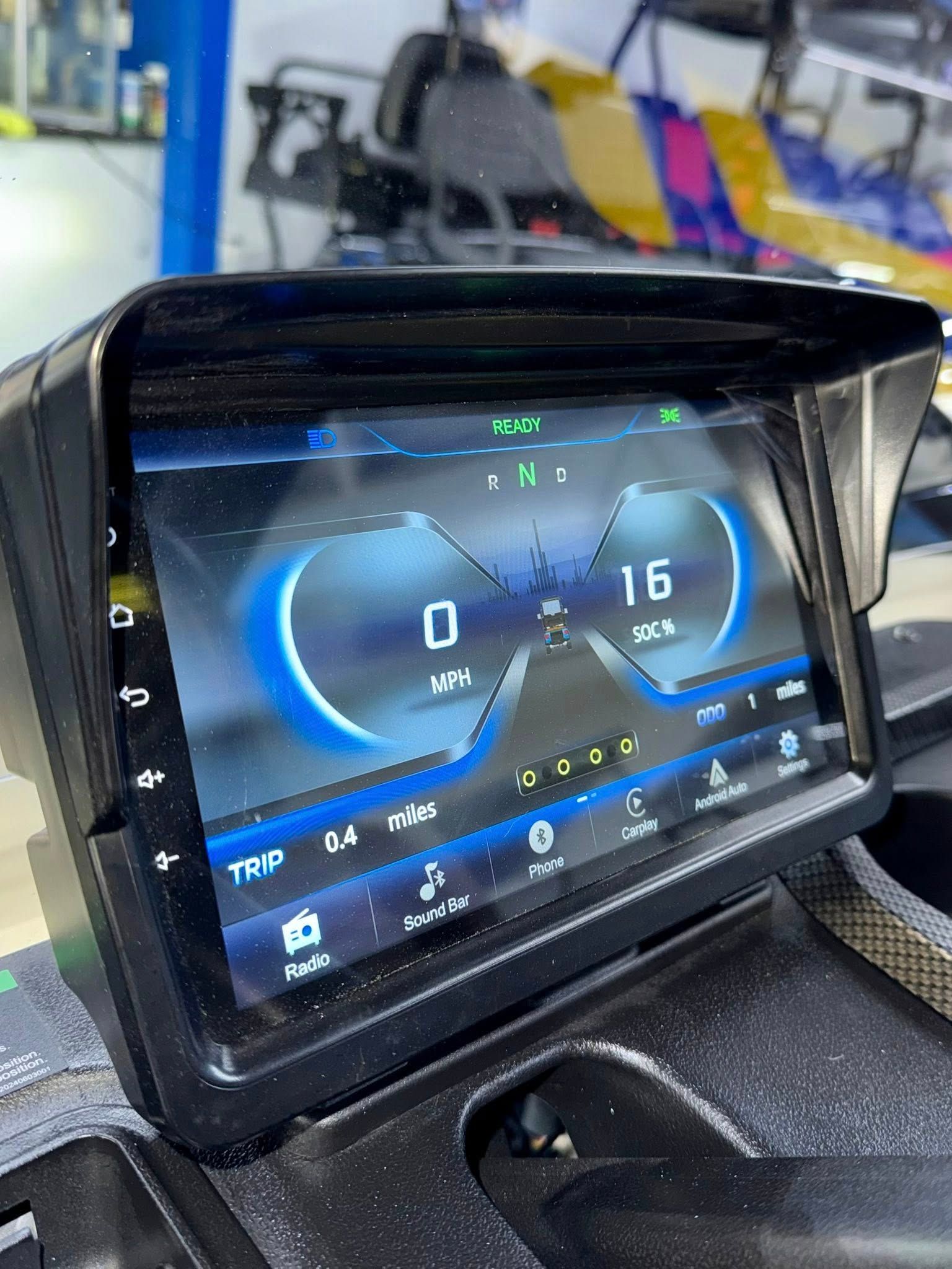Dashboard screen displays vehicle speed and data in a blue-lit digital interface, inside a buggy.