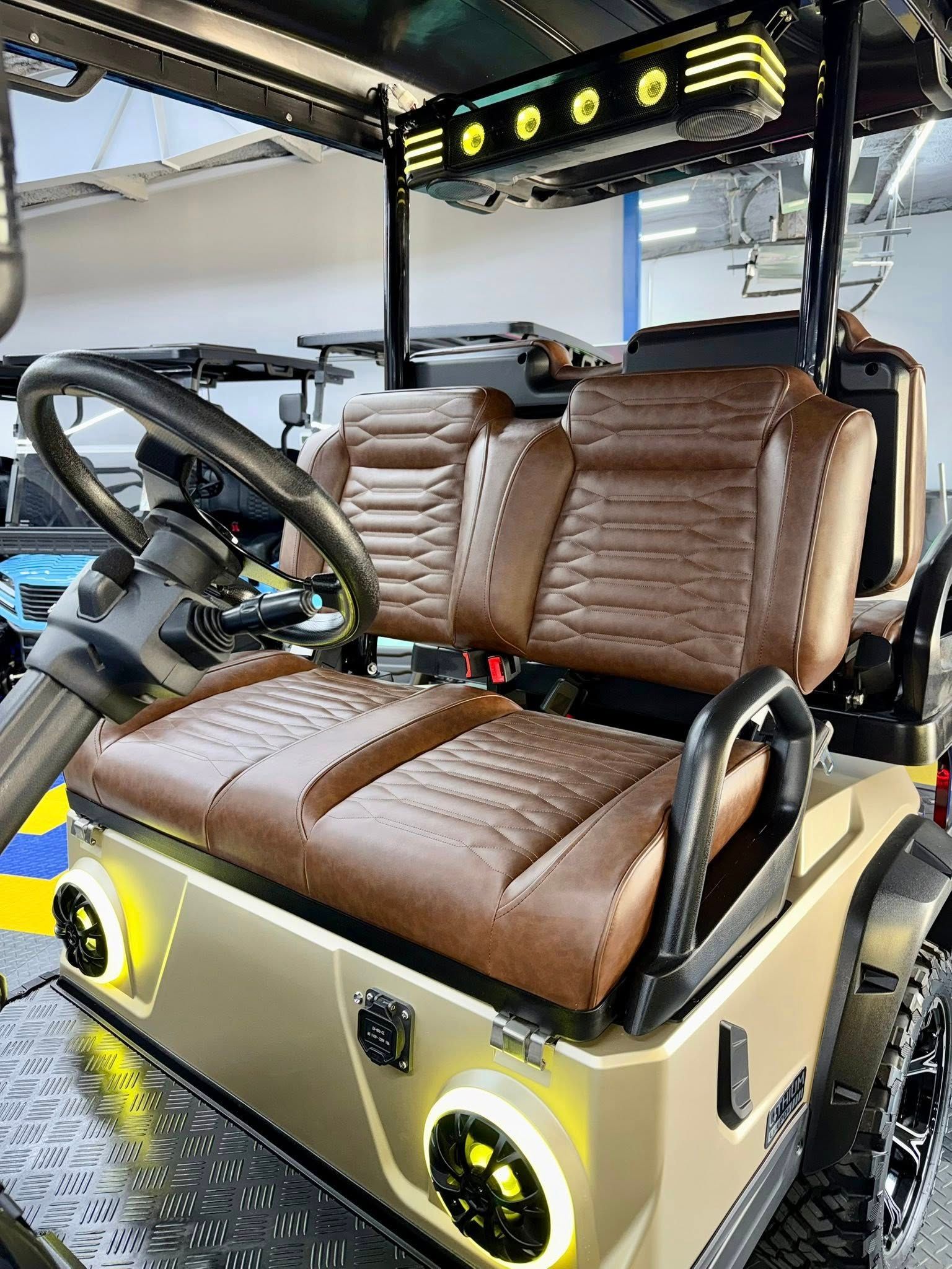 Tan golf cart with brown seats, black steering wheel, and custom lighting.