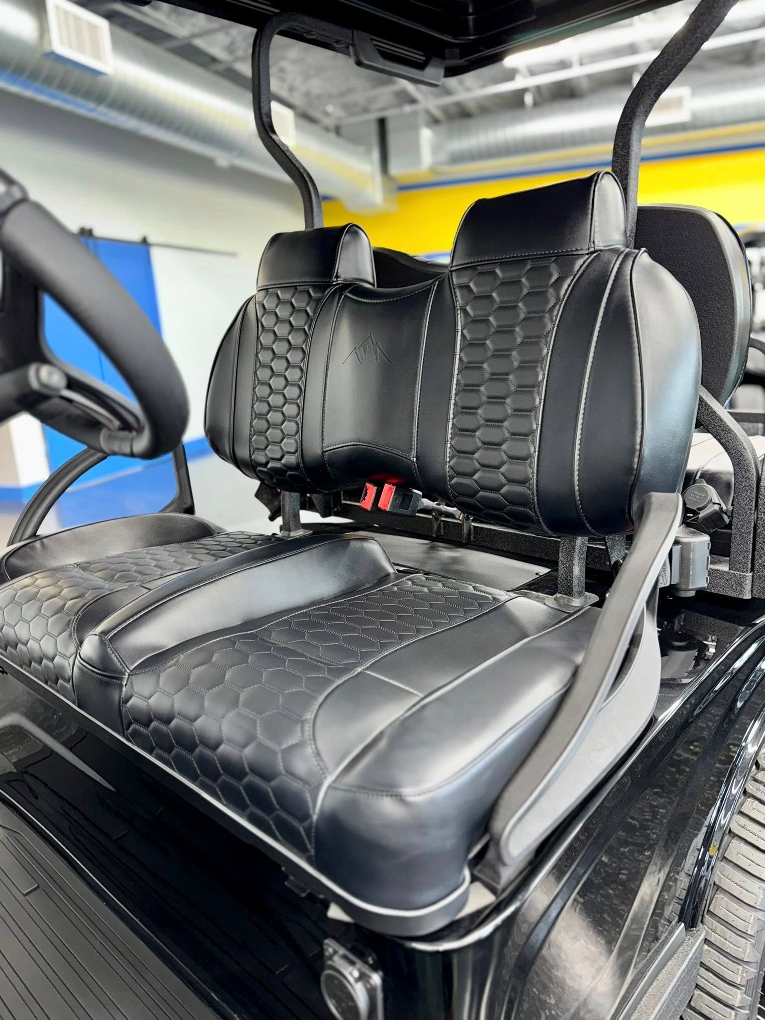 Black golf cart seat with stitched details and a textured pattern.