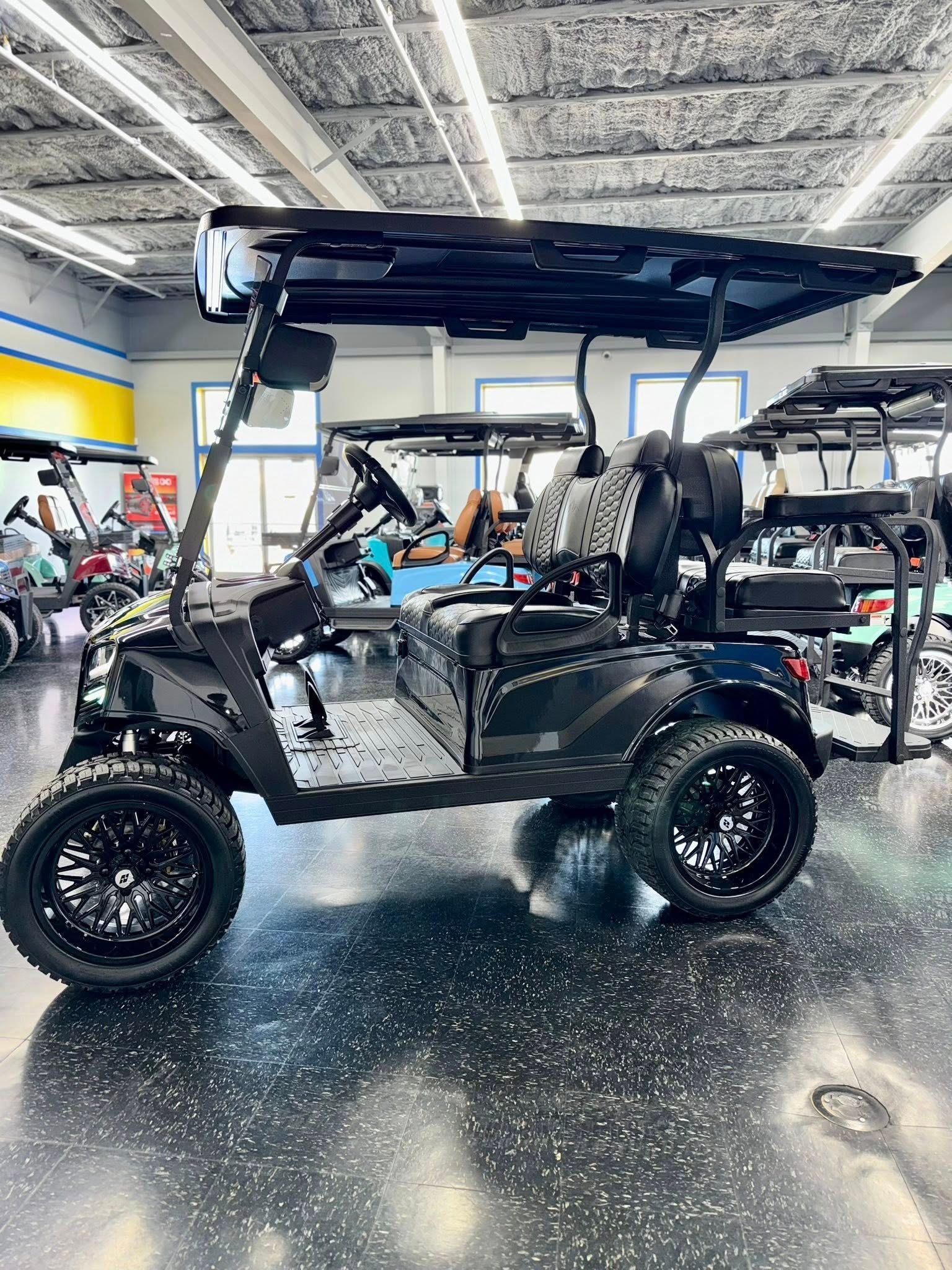 Black golf cart with large wheels, inside a showroom.
