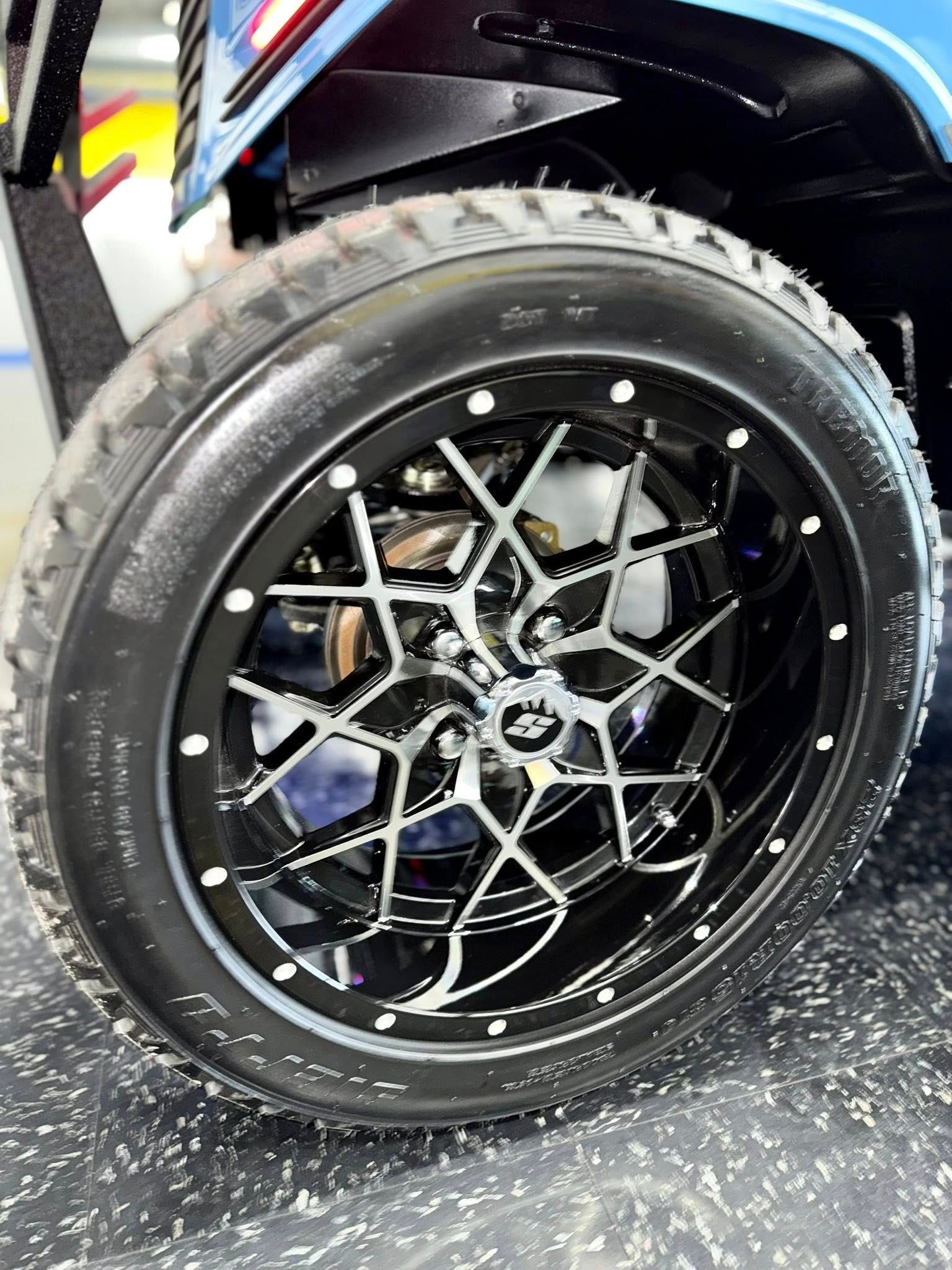 Black and silver custom golf cart wheel with a large tire.