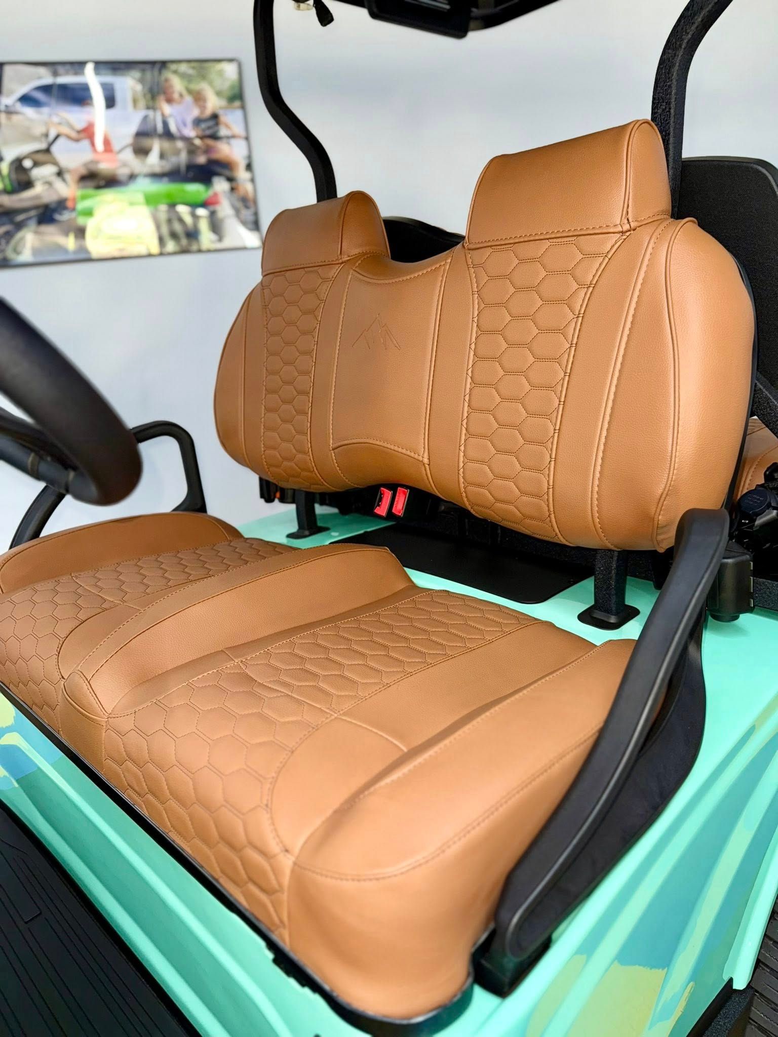 Tan golf cart seats with patterned stitching.