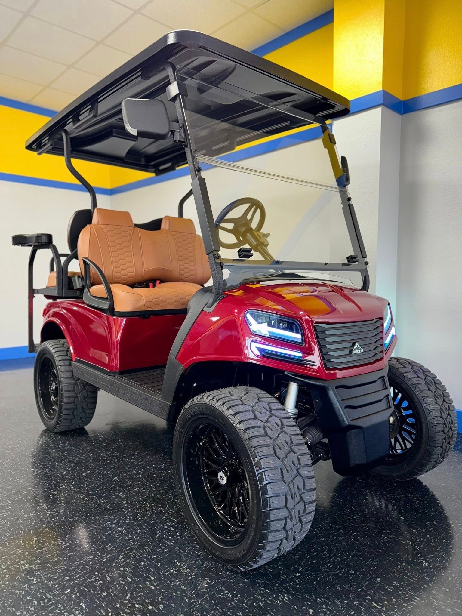 Red golf cart with black wheels, roof, and tan seats.