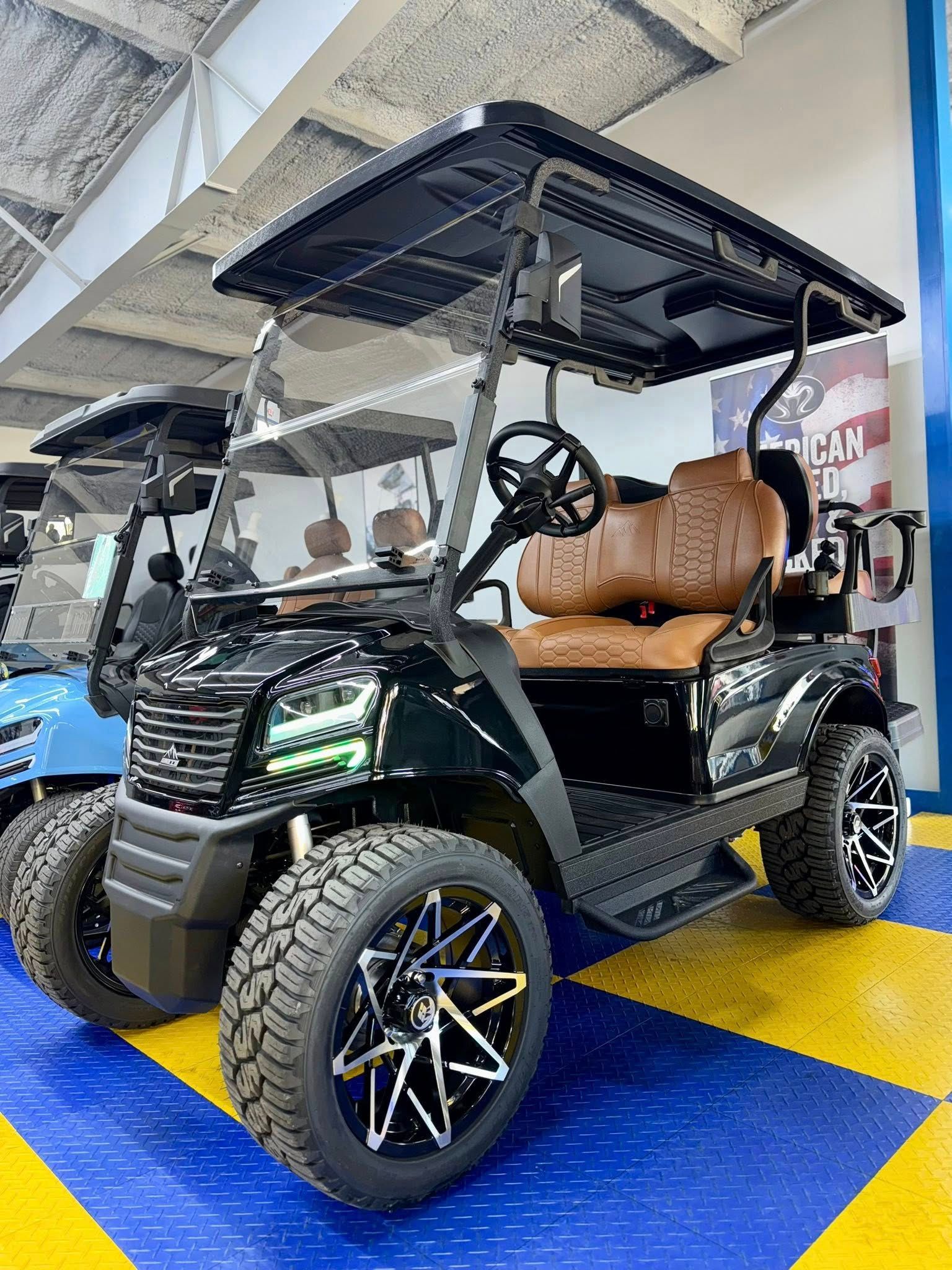 Black golf cart with brown seats and black wheels, parked indoors on a blue and yellow floor.