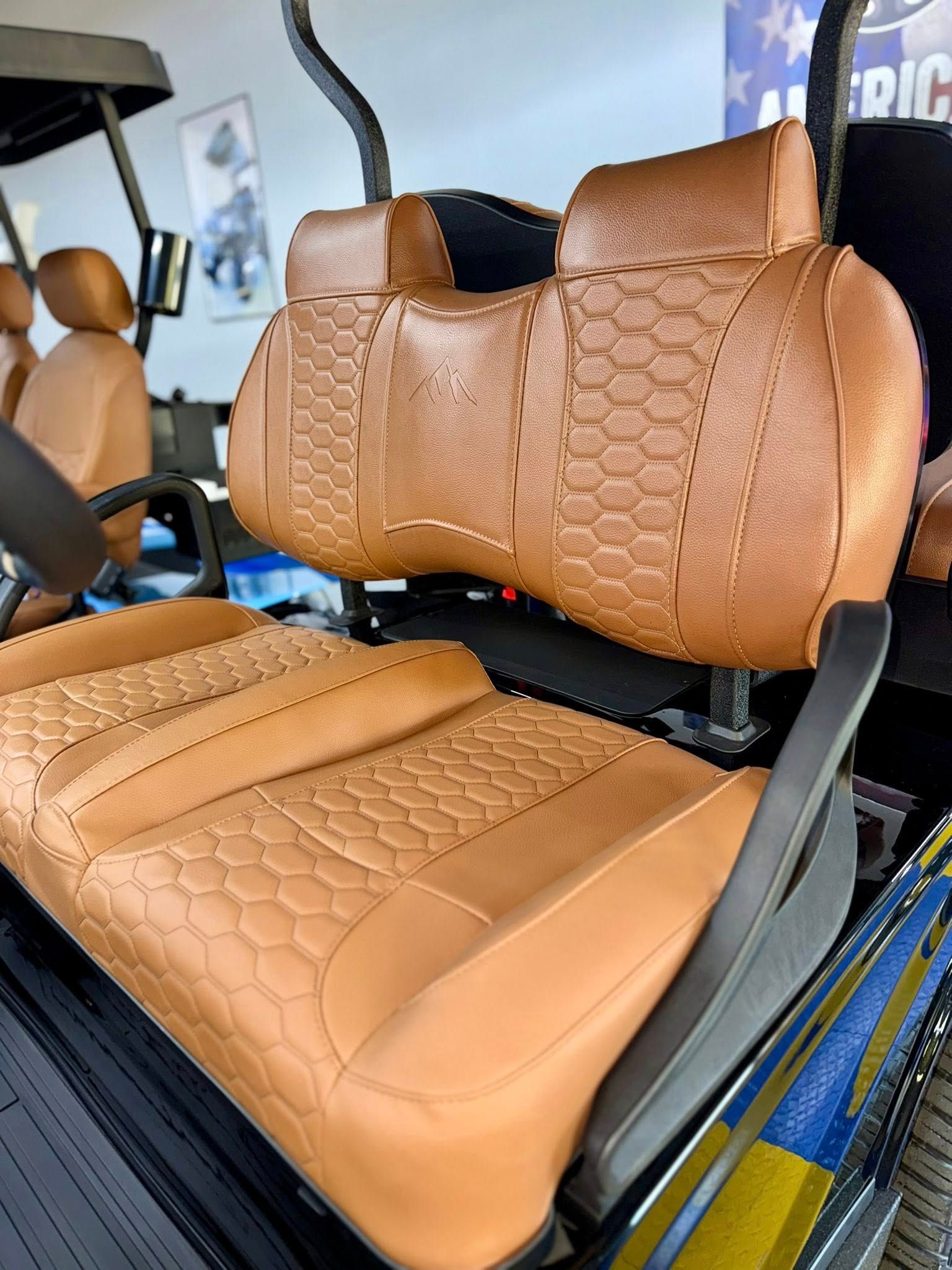 Tan golf cart seats with honeycomb stitching detail.