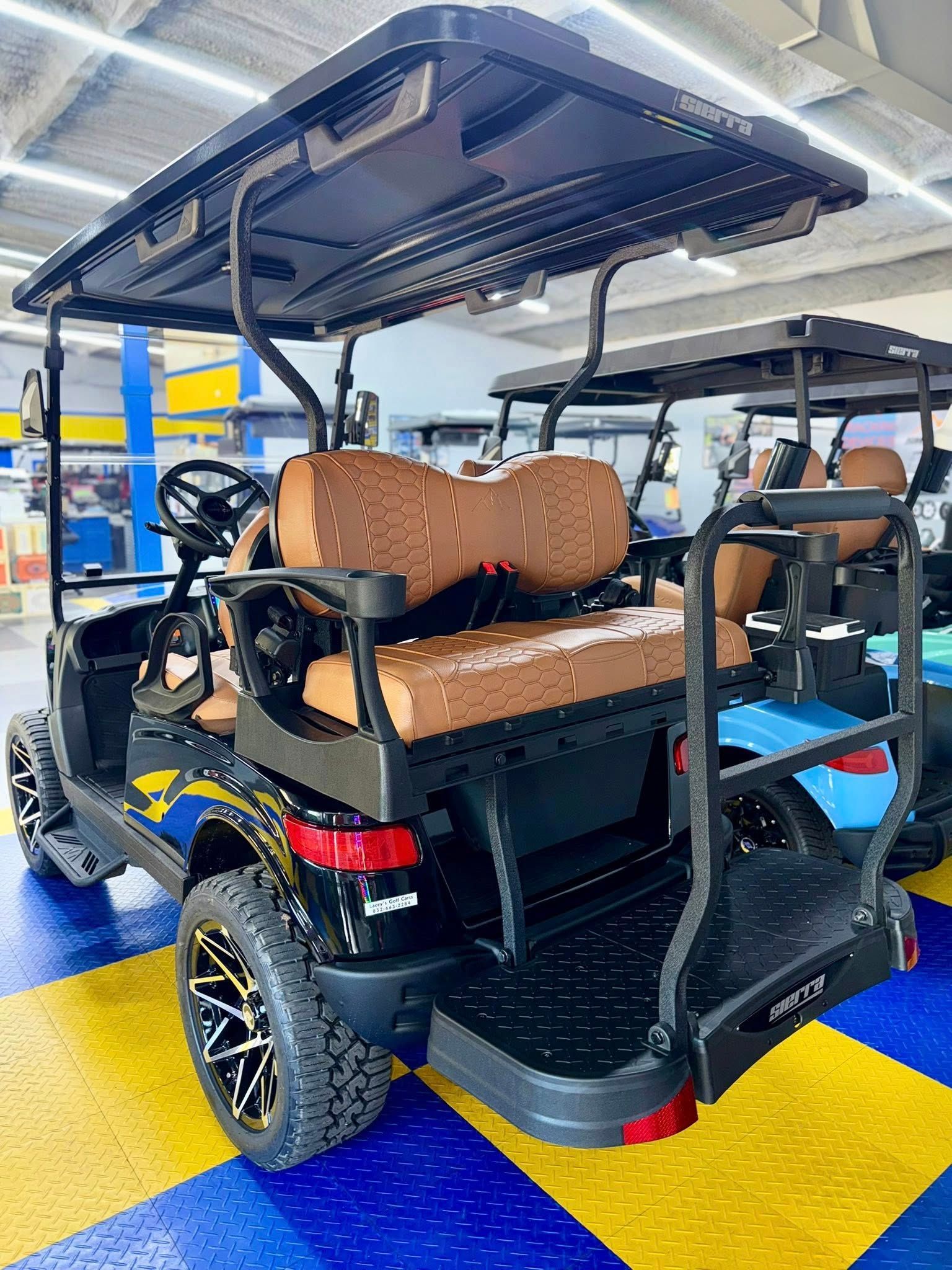 Black and brown golf cart with tan seating, black wheels, and a rear step in an indoor setting.