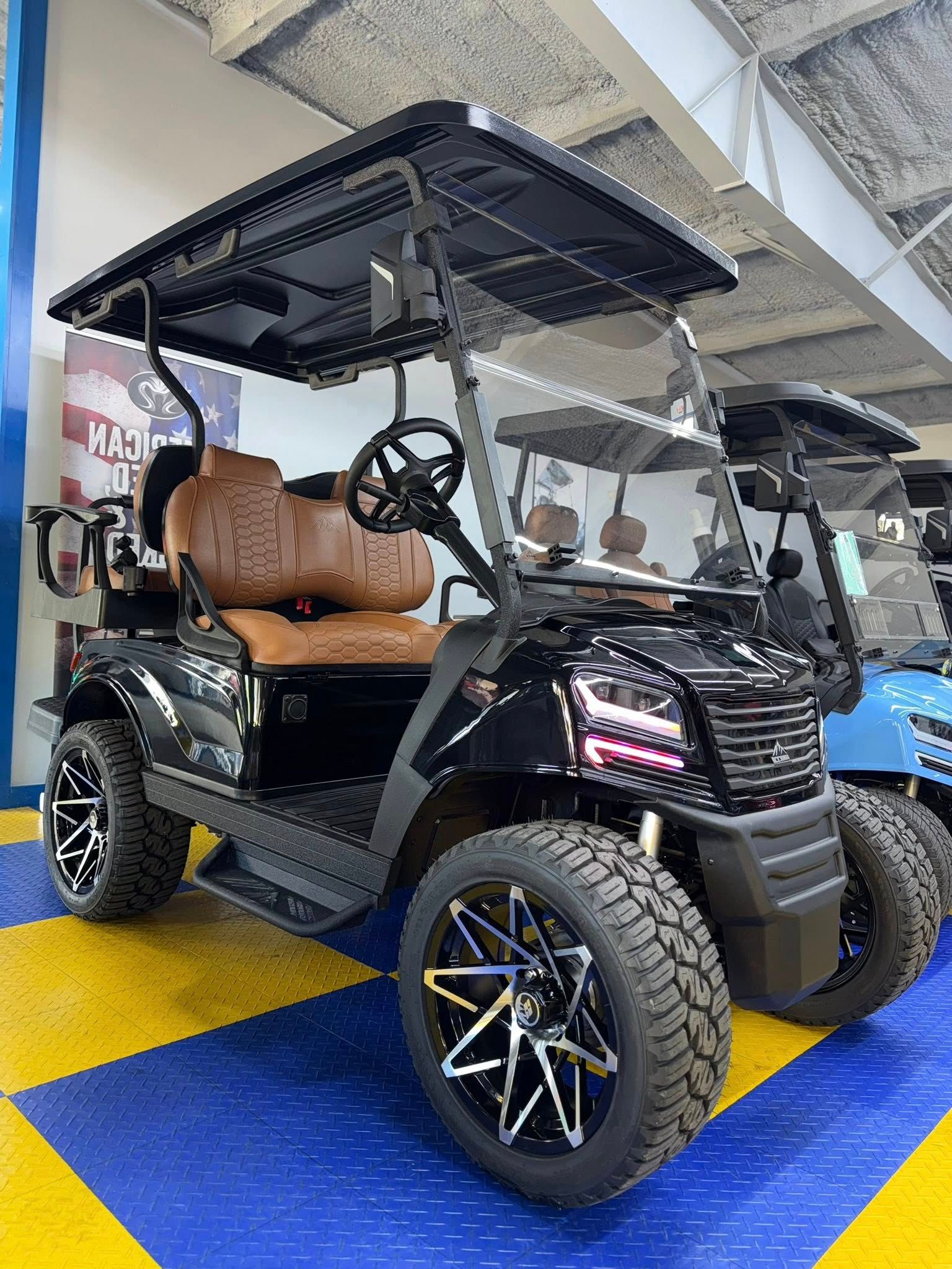 Black golf cart with brown seats, large wheels, and a windshield.
