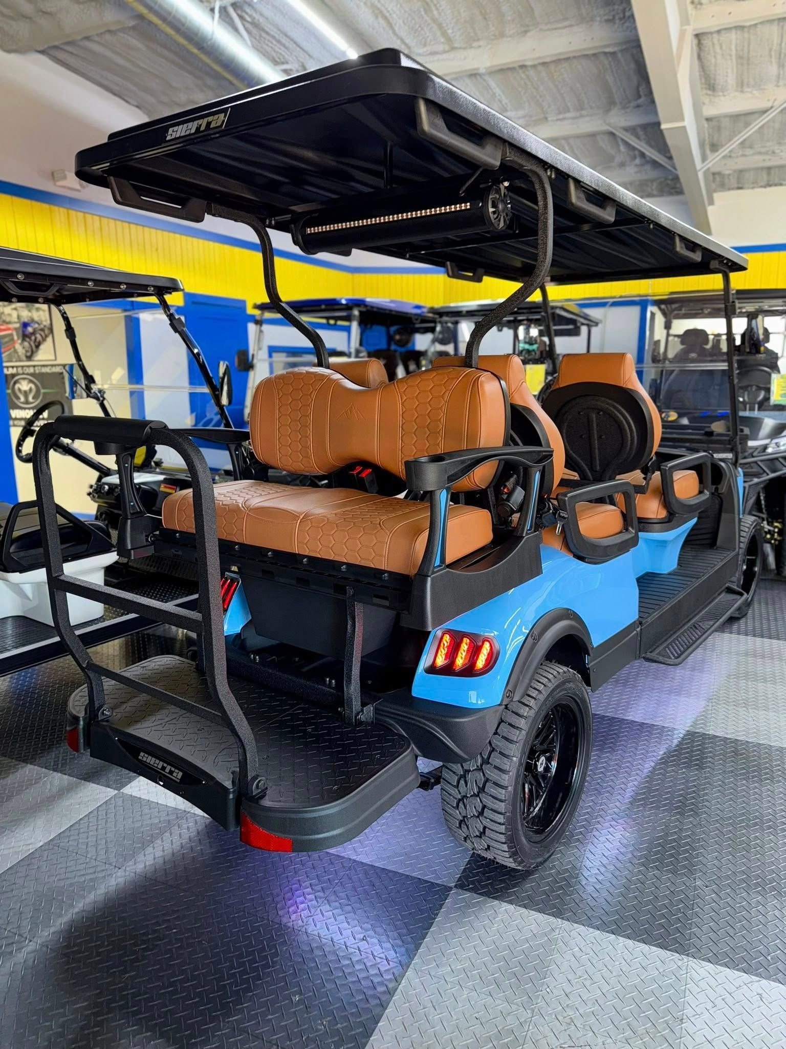 Blue and black golf cart with tan seats, parked inside a showroom.