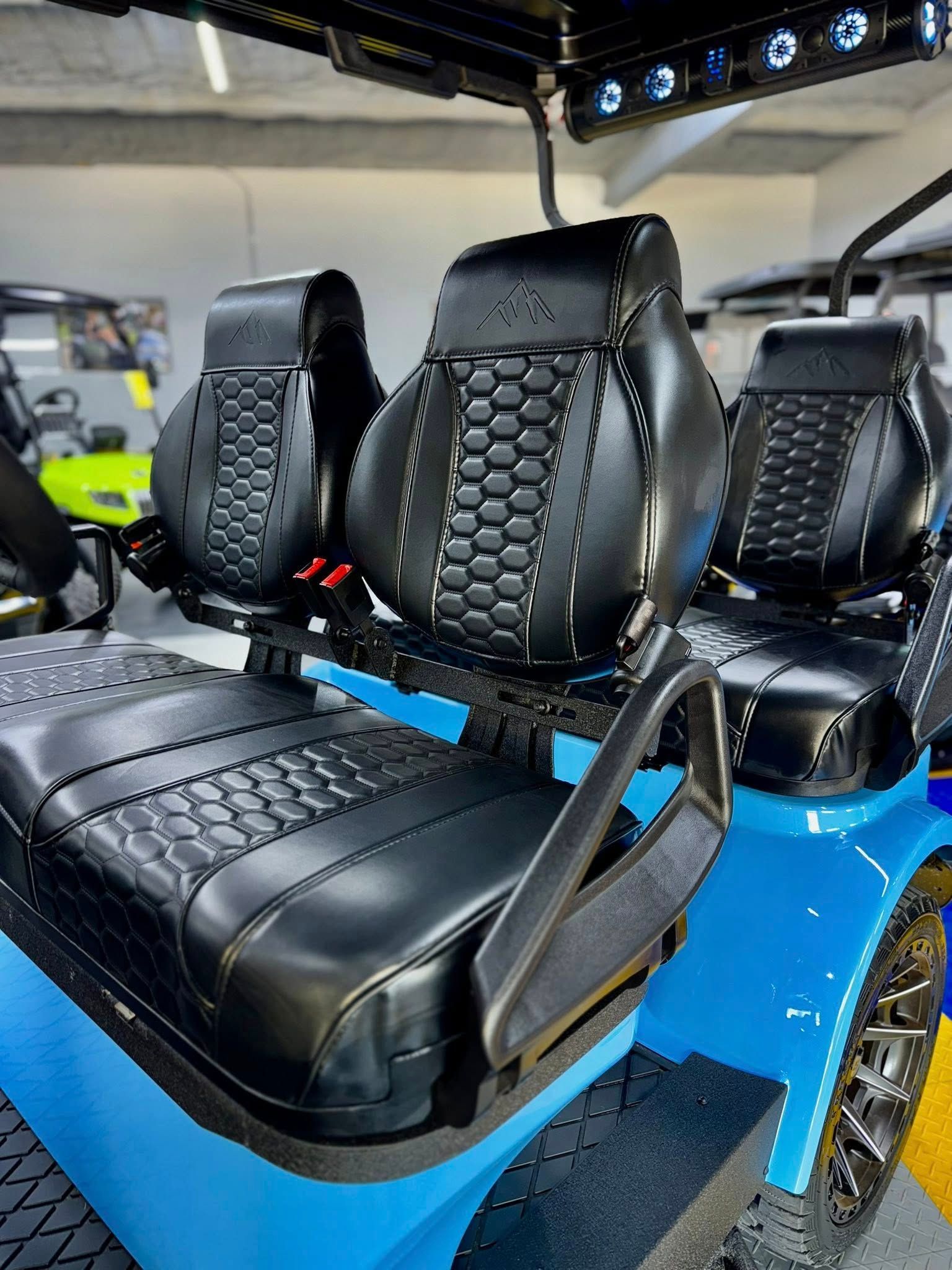 Blue golf cart with black, textured seats.