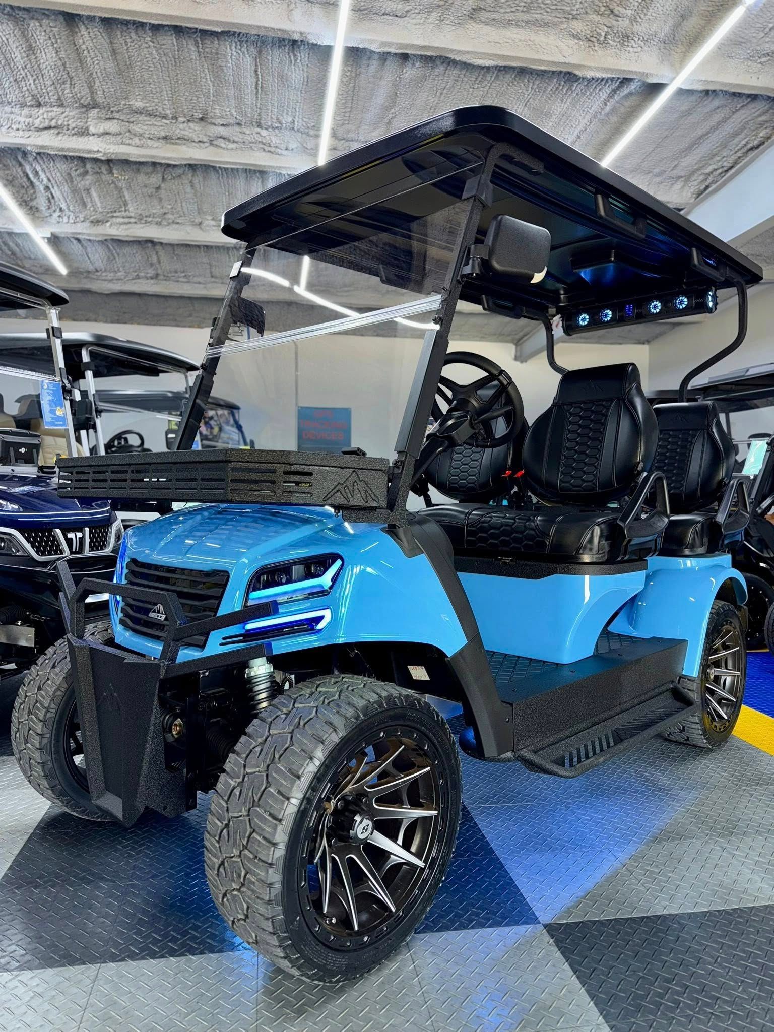 Blue custom golf cart with black accents and off-road tires, indoors.