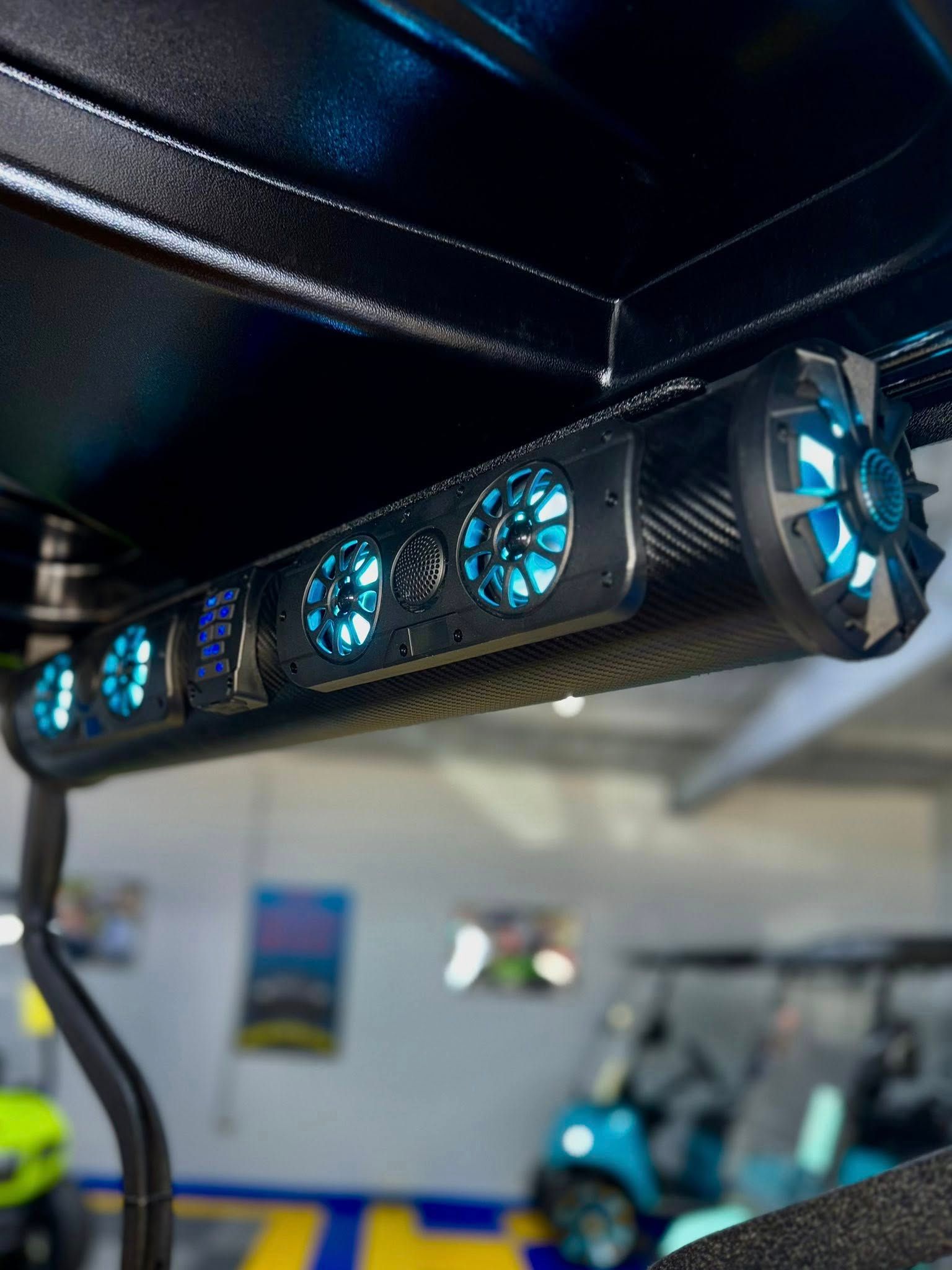 Black golf cart soundbar with blue LED lights.